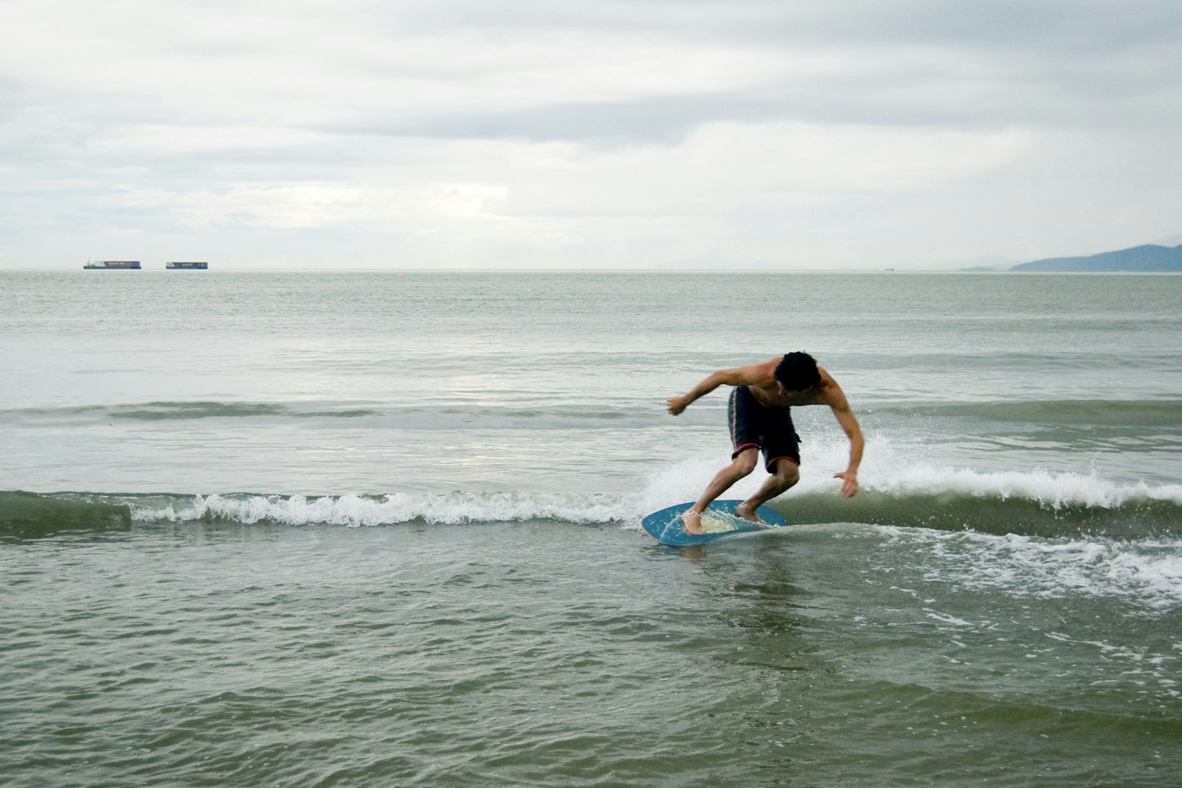 A man surfing on an overcast day