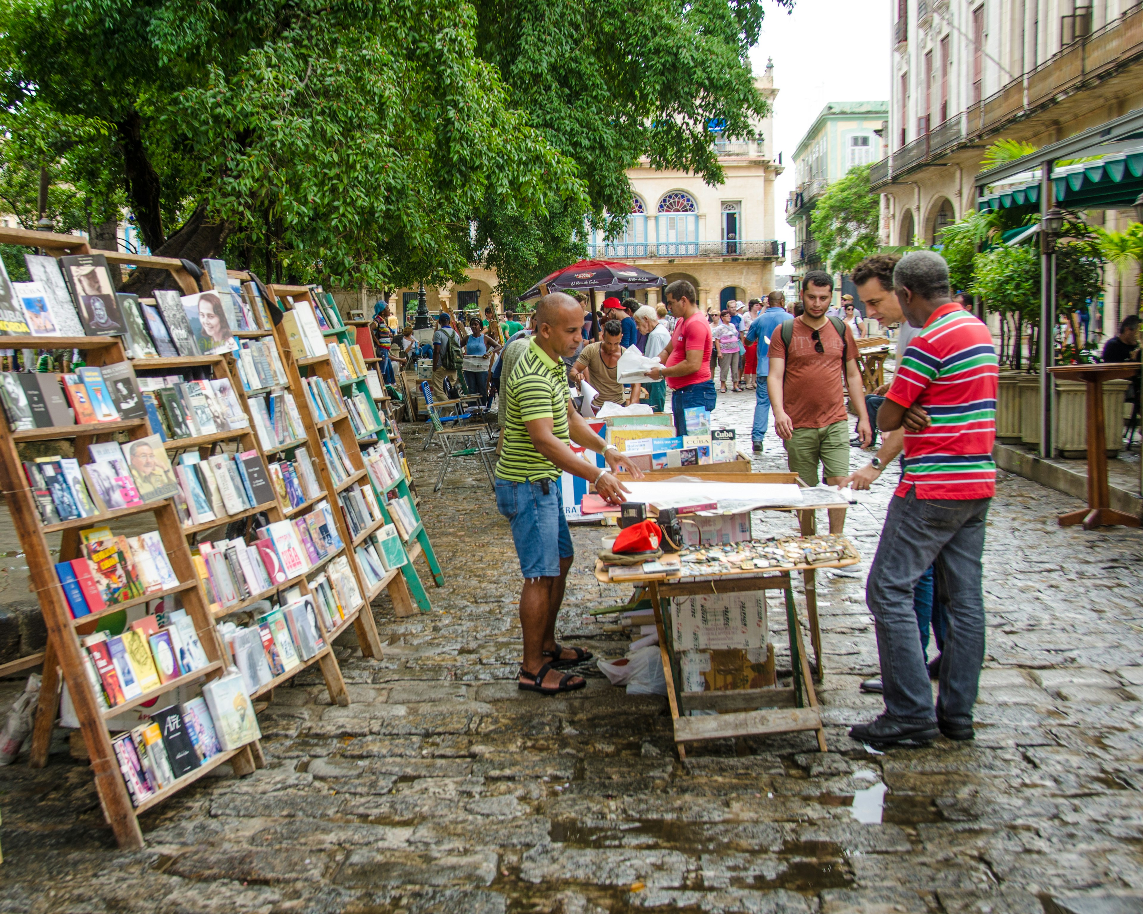 Tourists examine a poster at one of the stalls at Plaza de Armas selling books, magazines, art and antiques.