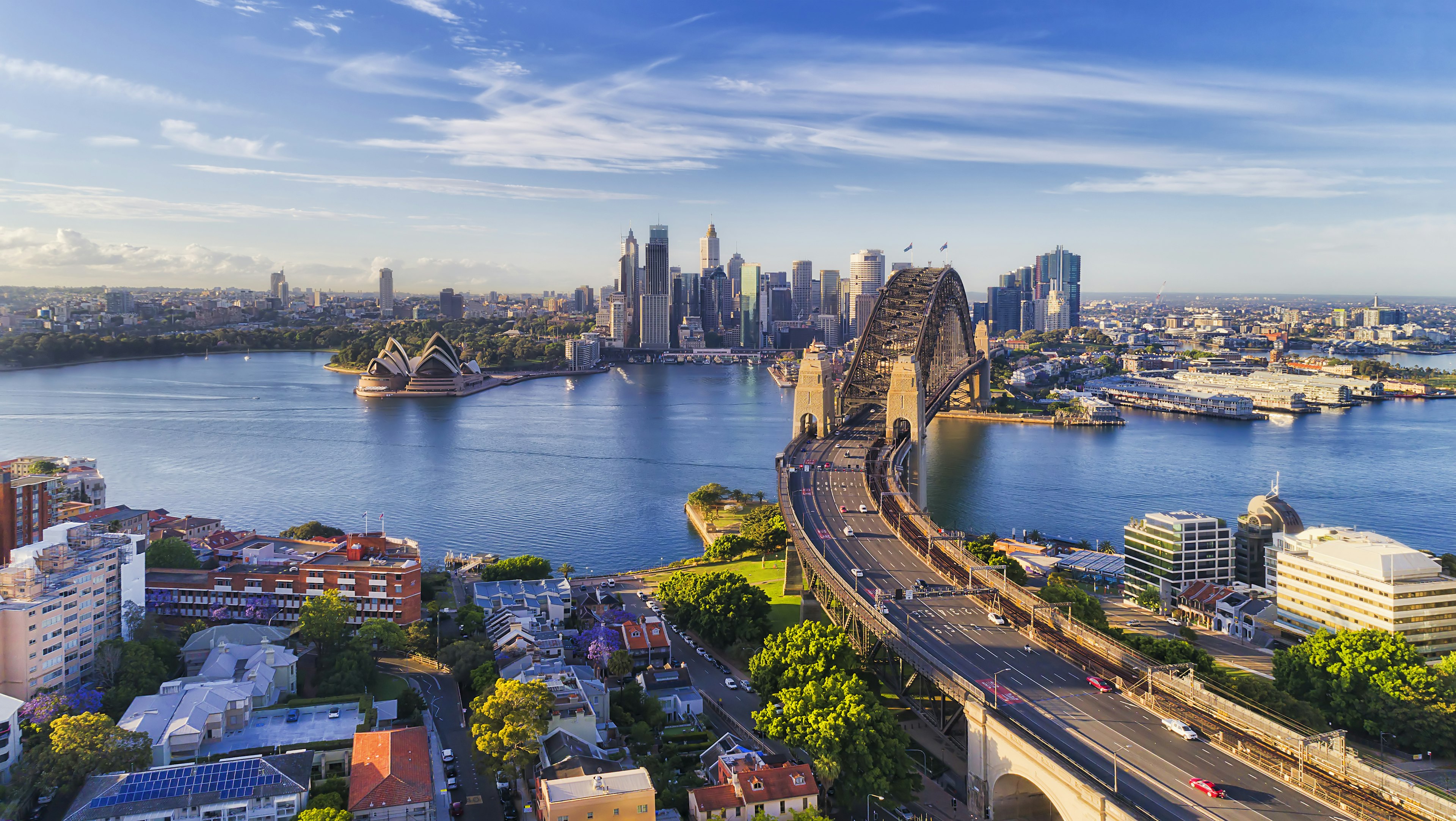 Cahill express way to the Sydney Harbour bridge across Sydney harbour towards city CBD landmarks in aerial eleveated wide view under blue morning sky tasmin waby