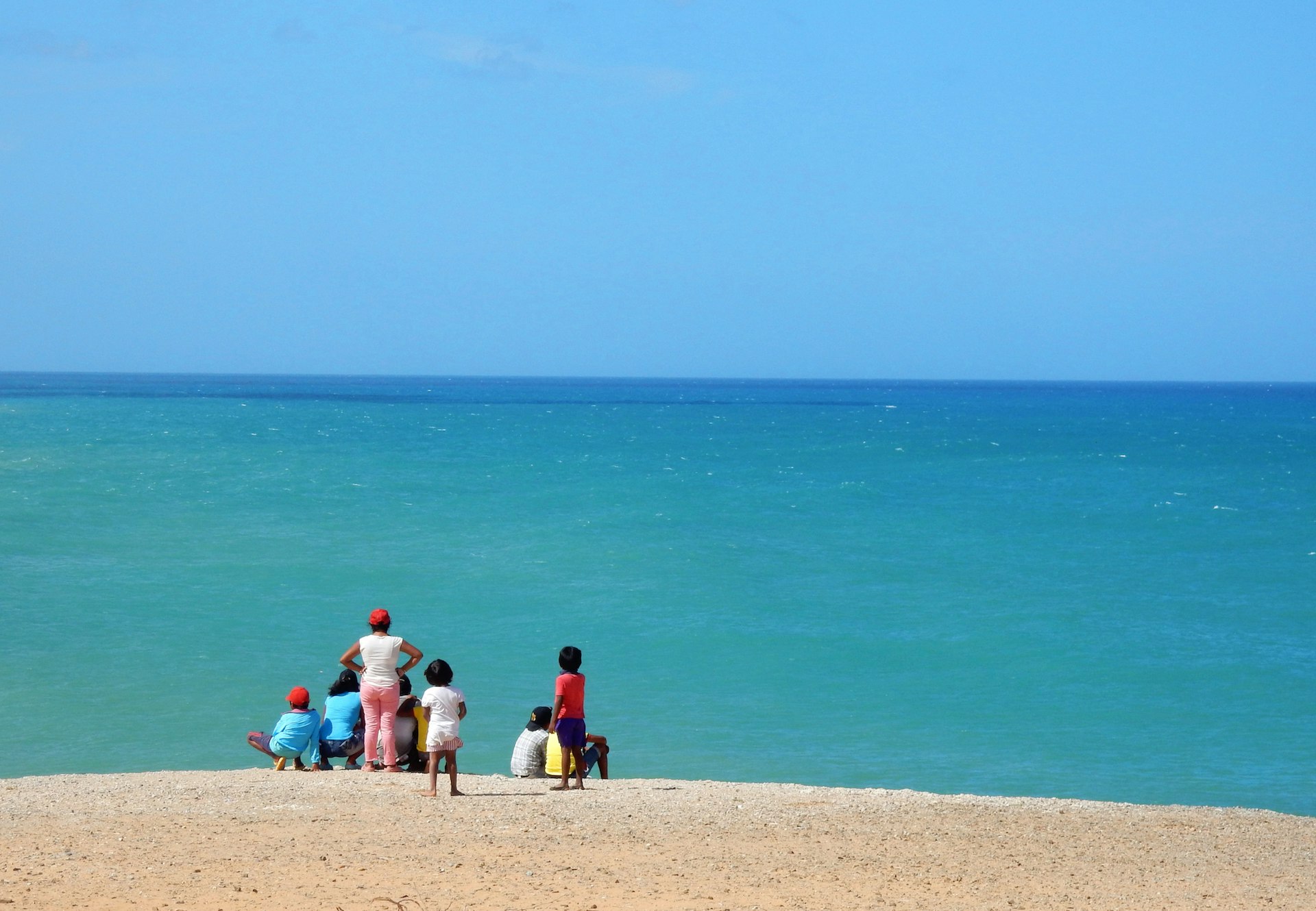 A family looks out at the ocean on La Guajira Peninsula, Colombia
