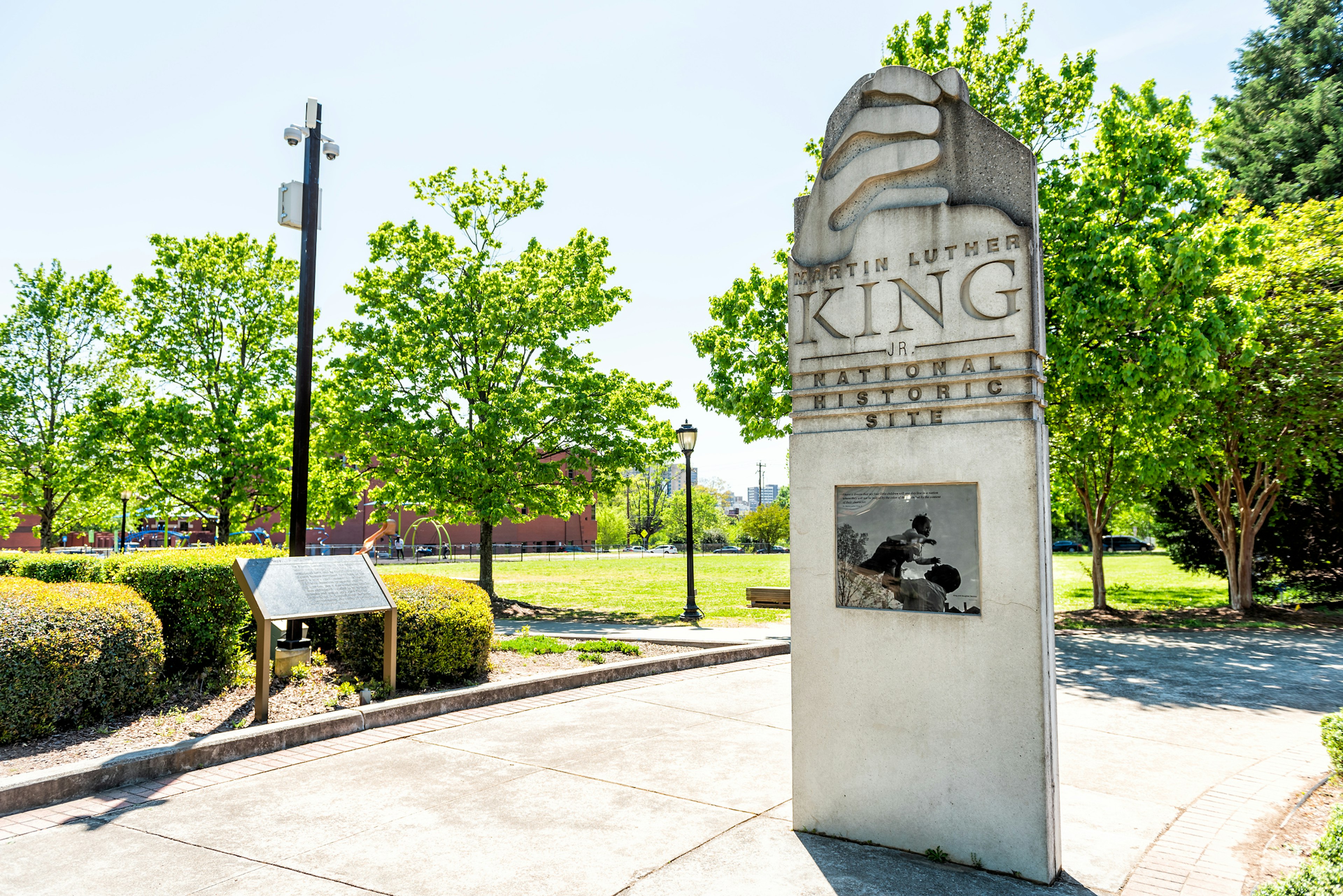 Sign to Martin Luther King Jr National historic site in Georgia city in summer with park view