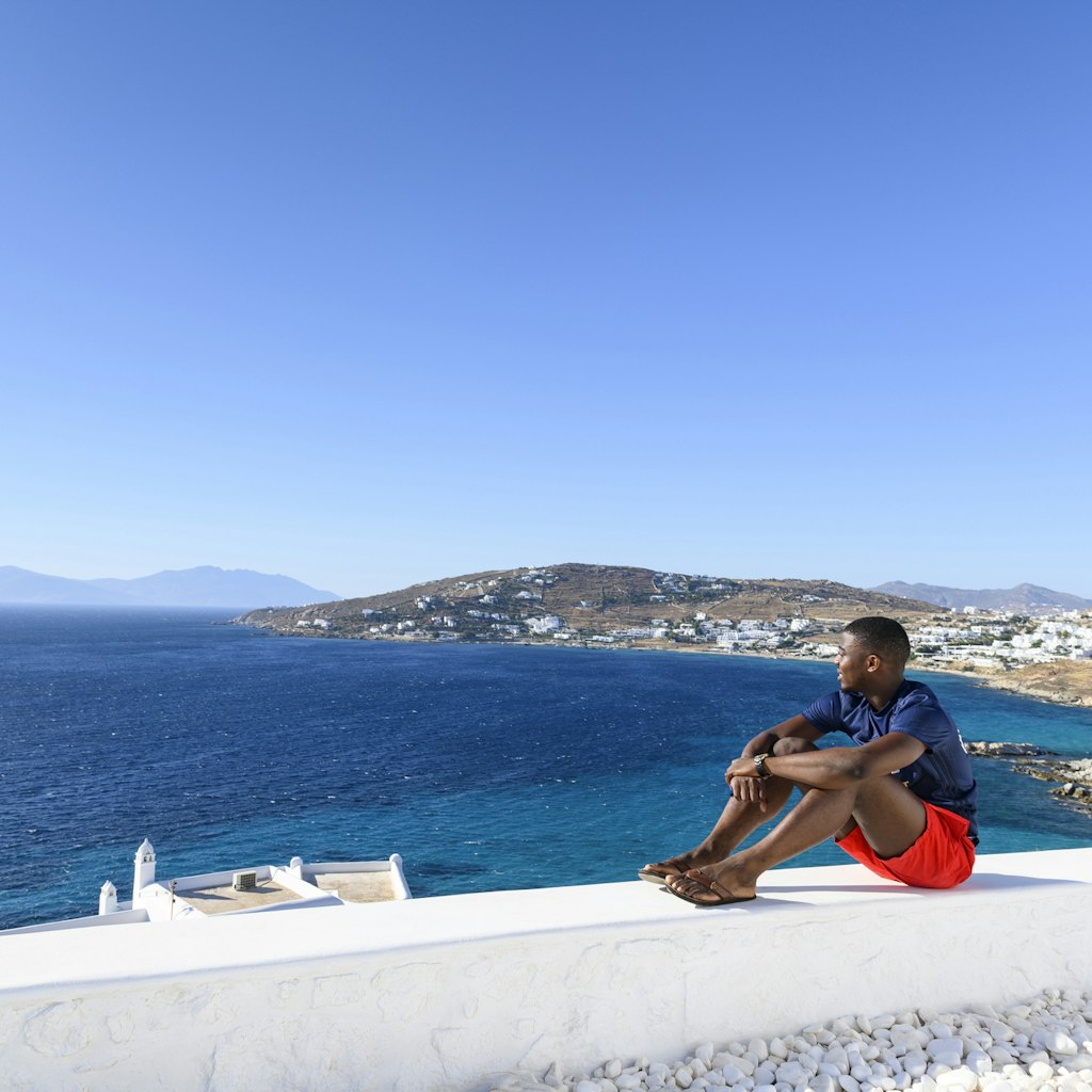 The African man sits on a white wall and admires the view.
1167004783
