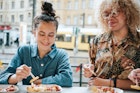 portrait of two teenage girls eating curry sausage with french fries at kiosk outdoors on berlin streets
1372731342
Two teenage girls eating curry sausage with french fries in berlin