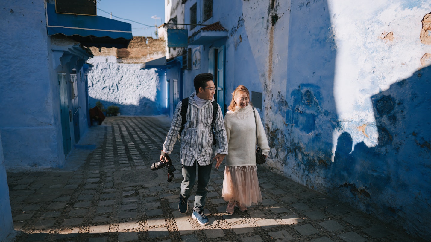 Asian Chinese tourist couple walking in alley of Chefchaouen, Morocco
1445105036
A couple walks through the blue city of Morocco.