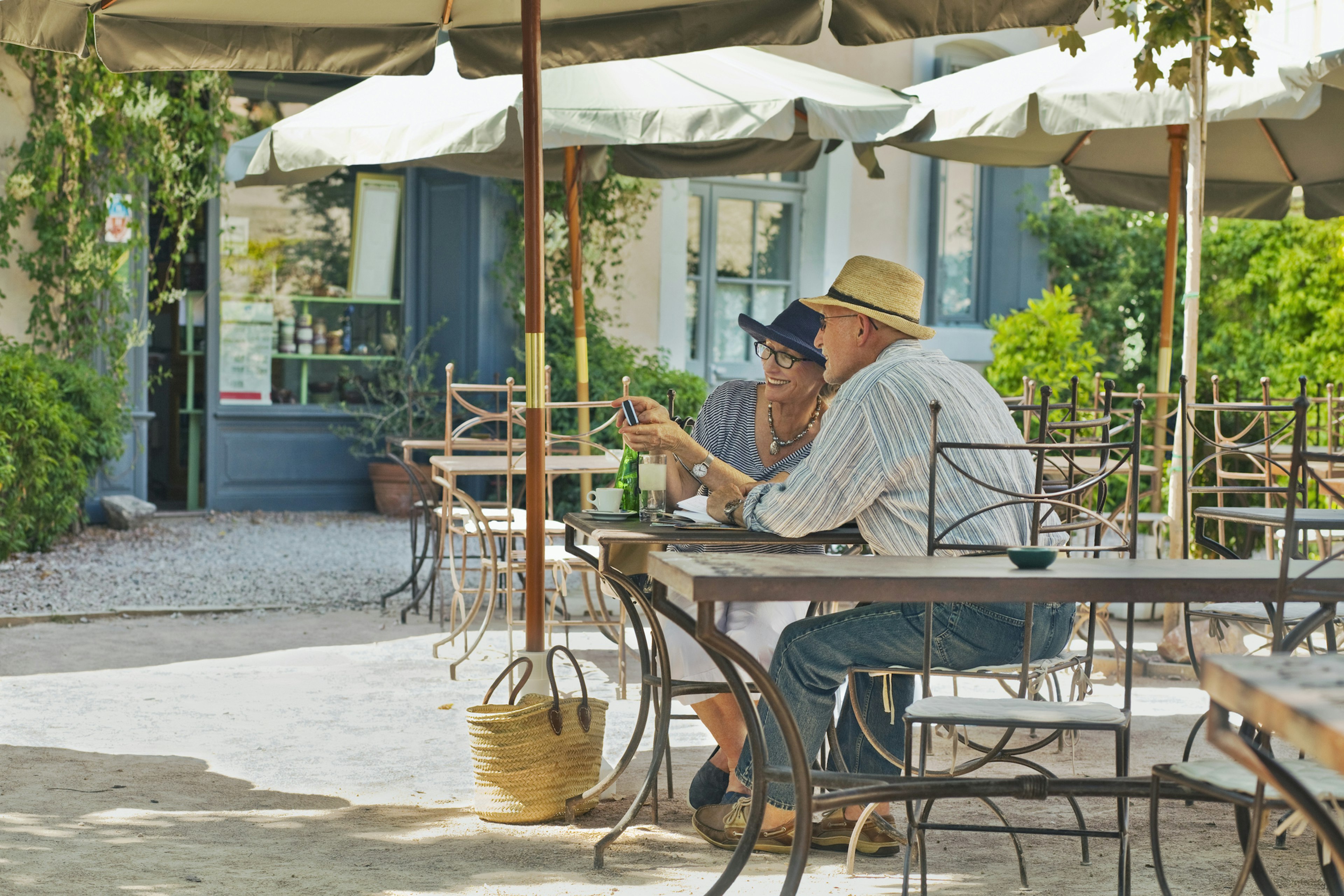 An older smile as they sit at an outside table at a cafe in Carcassonne