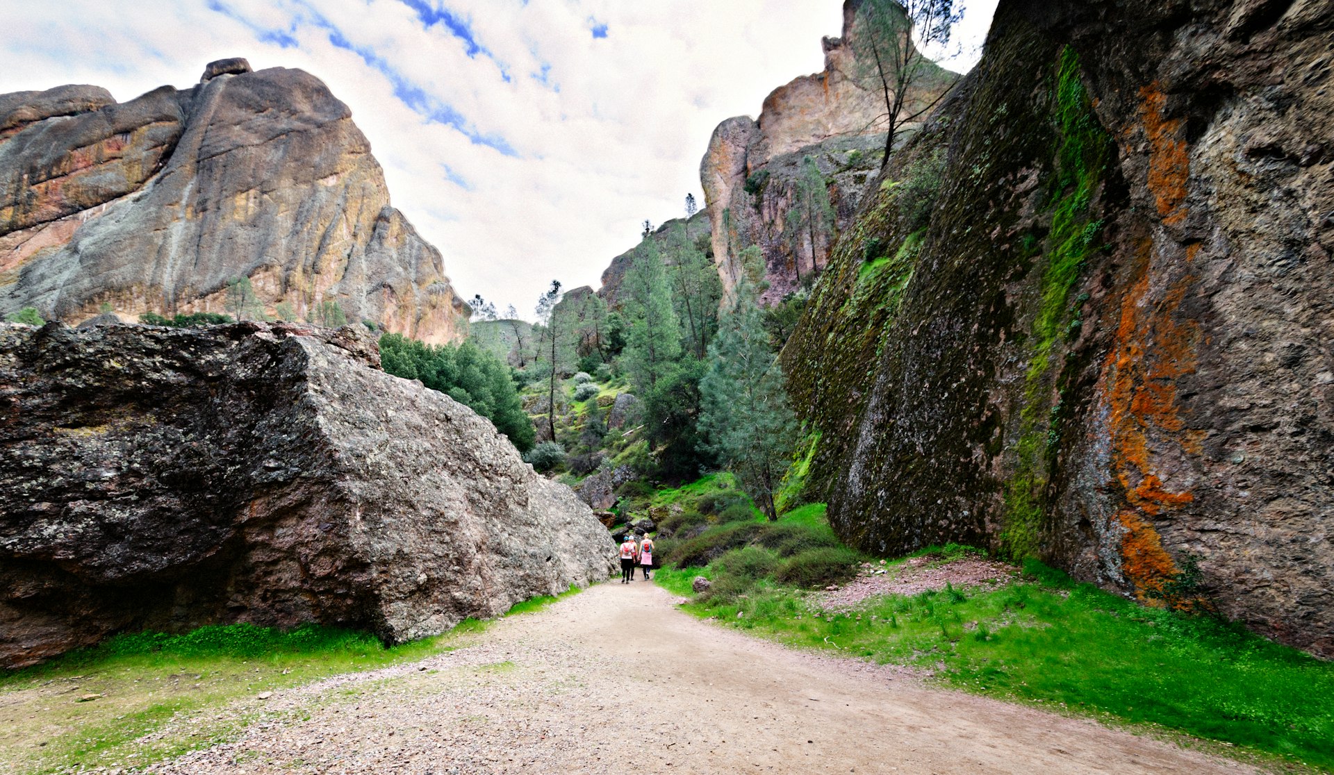 Hikers on a trail leading in spring through the Balconies Cliffs to the Balconies Caves, Pinnacles National Park, Soledad, California, USA