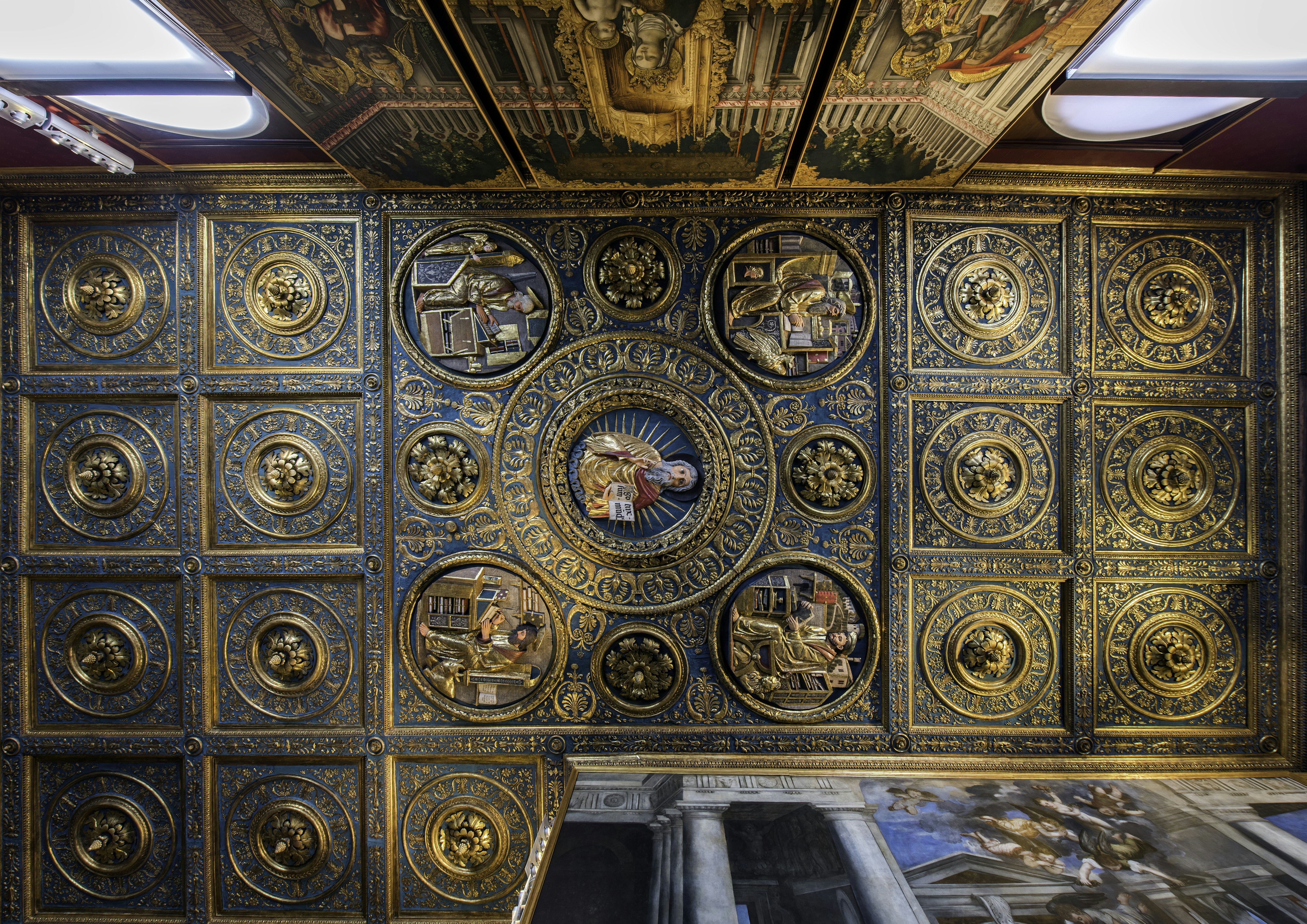 A detailed ceiling including frescos, plasterwork, painted figures and golden edges