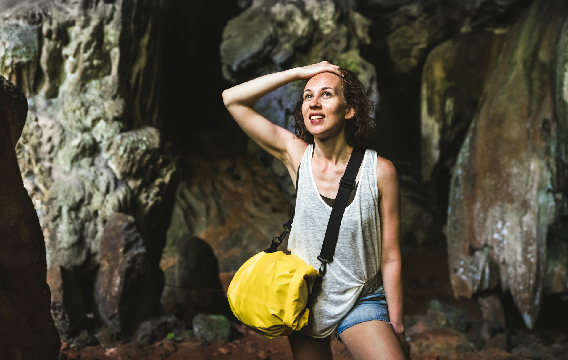 Young woman traveler at a cave entrance in Cheow Lan Lake, Thailand