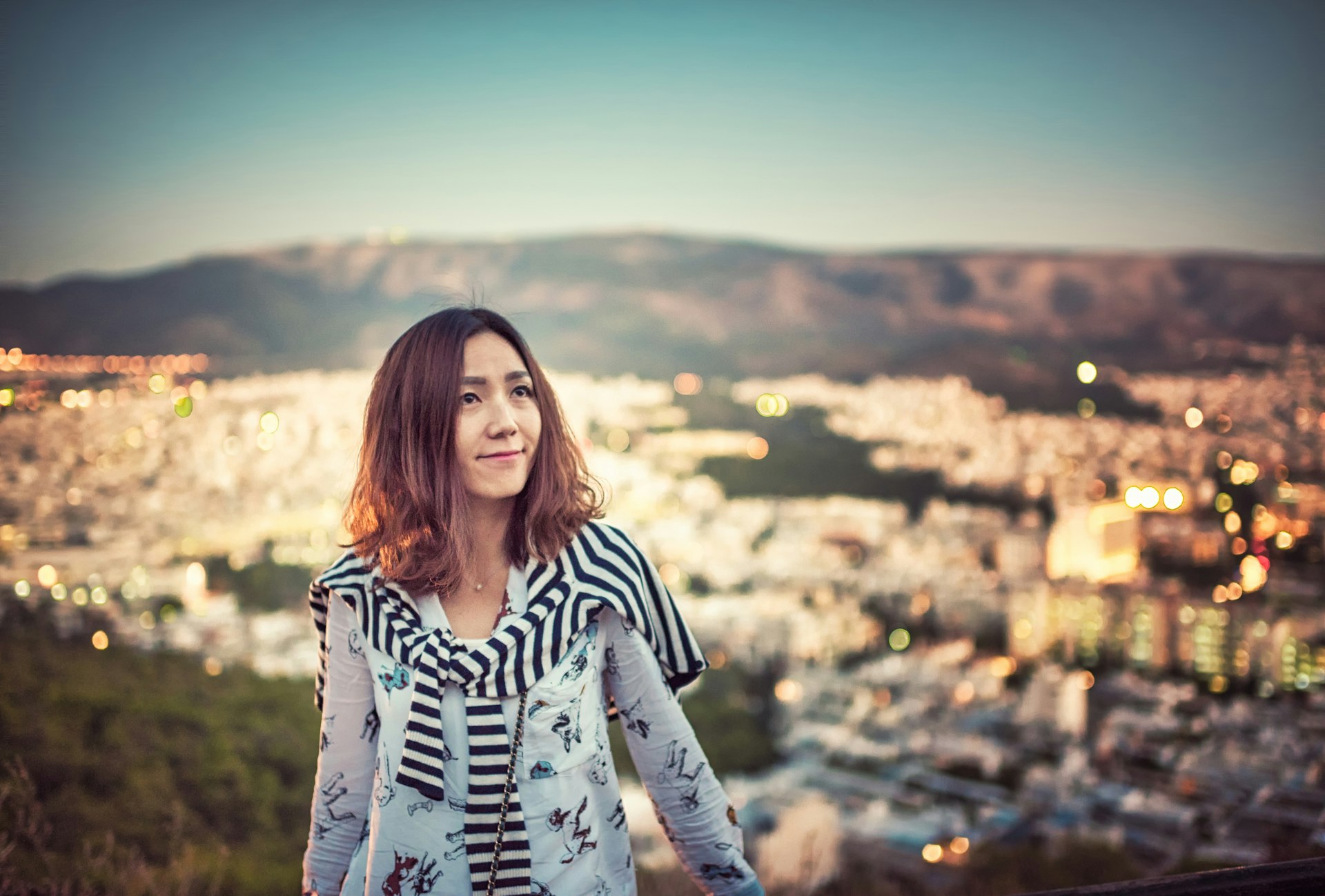 A young woman smiles above Athens