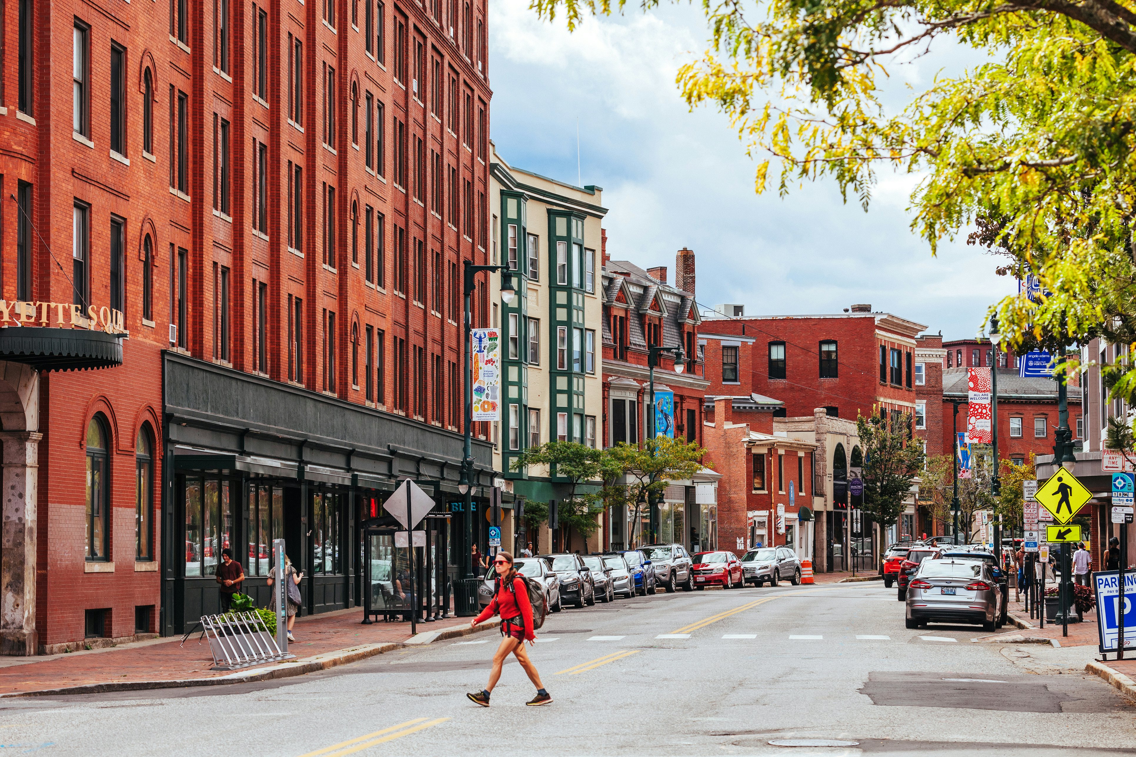 Woman in red walking across a pretty American downtown