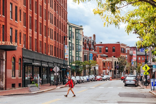 Woman in red walking across a pretty American downtown