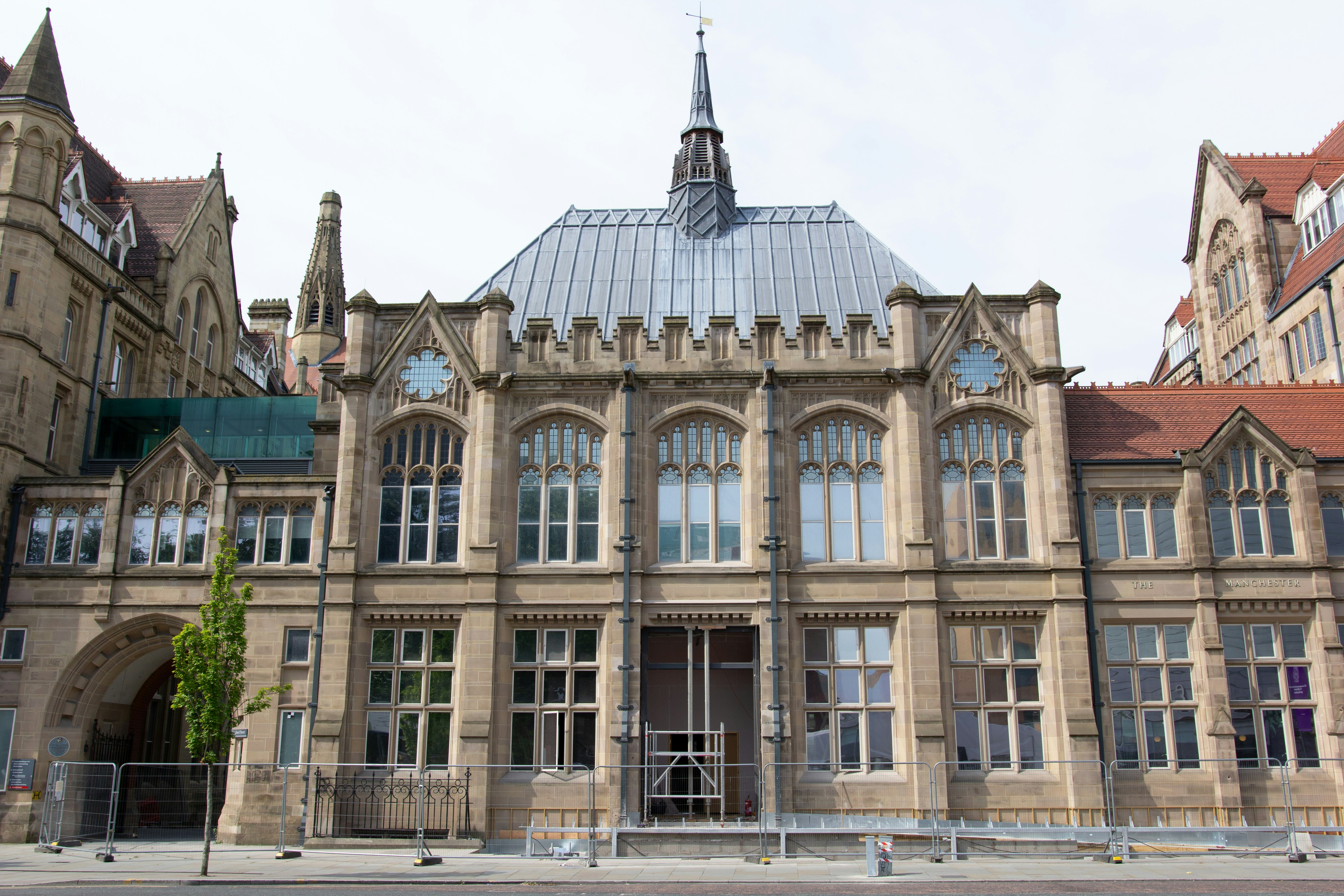 The new entrance of the Manchester Museum, a historic Victorian-style building. 
