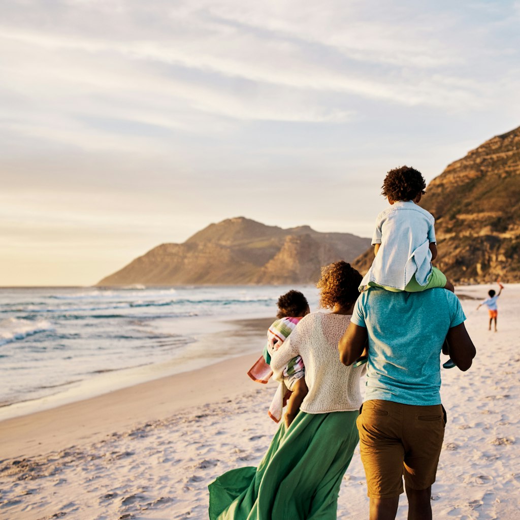 Rear of a family walking on the beach with copy space. African parents with little kids bonding and strolling by ocean. Little children enjoying the outdoors during their summer holidays or vacation
1408174631