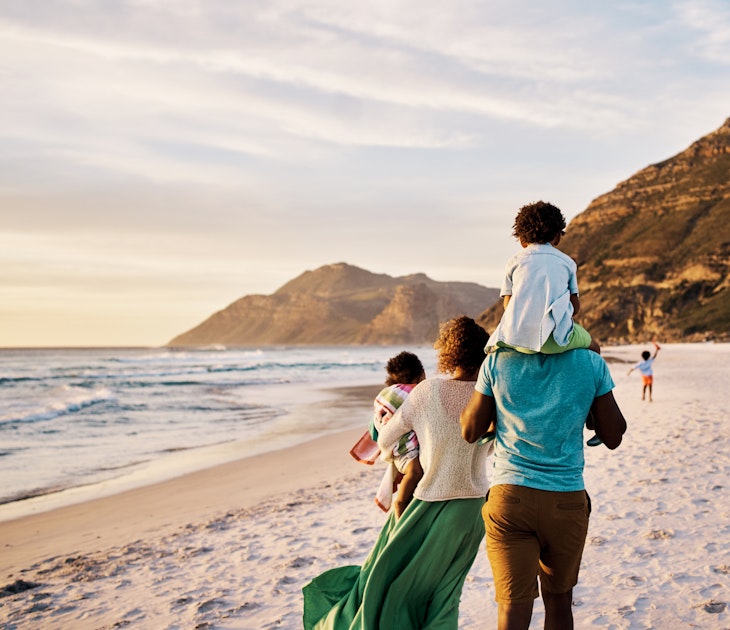 Rear of a family walking on the beach with copy space. African parents with little kids bonding and strolling by ocean. Little children enjoying the outdoors during their summer holidays or vacation
1408174631