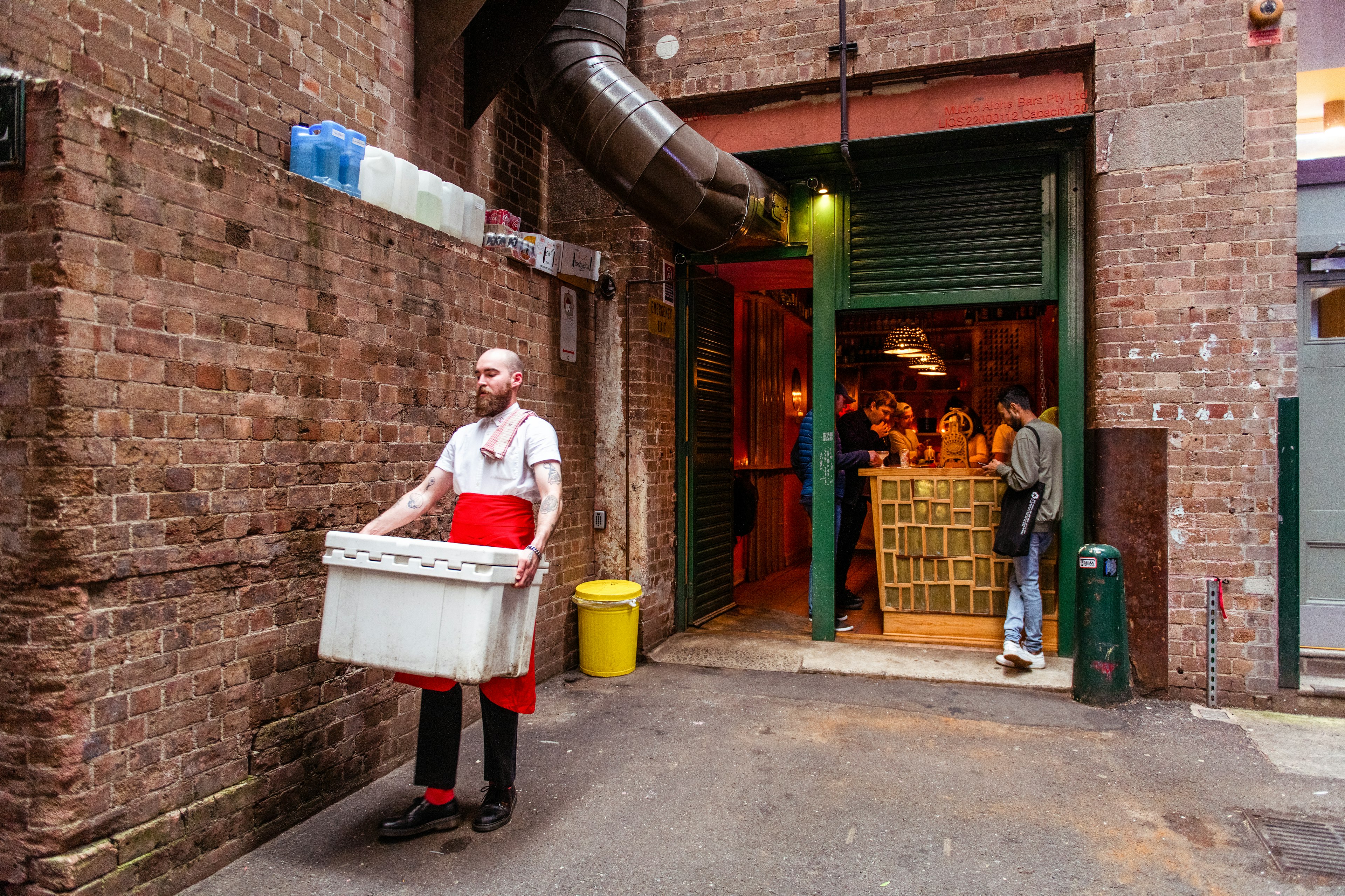 Man carrying a box outside Cantino OK! Sydney by Isabella Moore