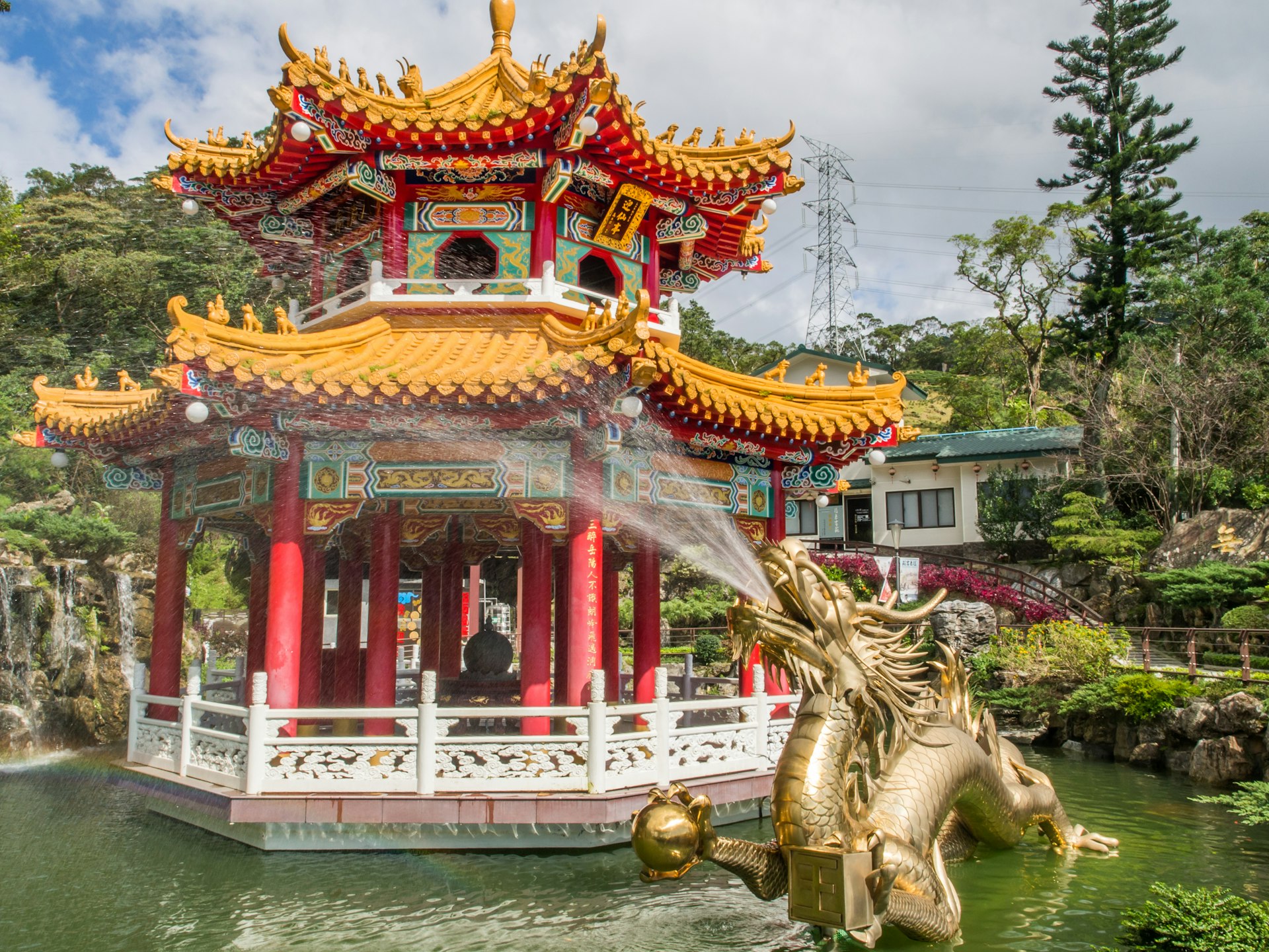 A colorful pagoda floating and a gold dragon fountain with water coming out of its mouth in Taipei, Taiwan, near the Zhinan Temple Station of Maokong Gondola