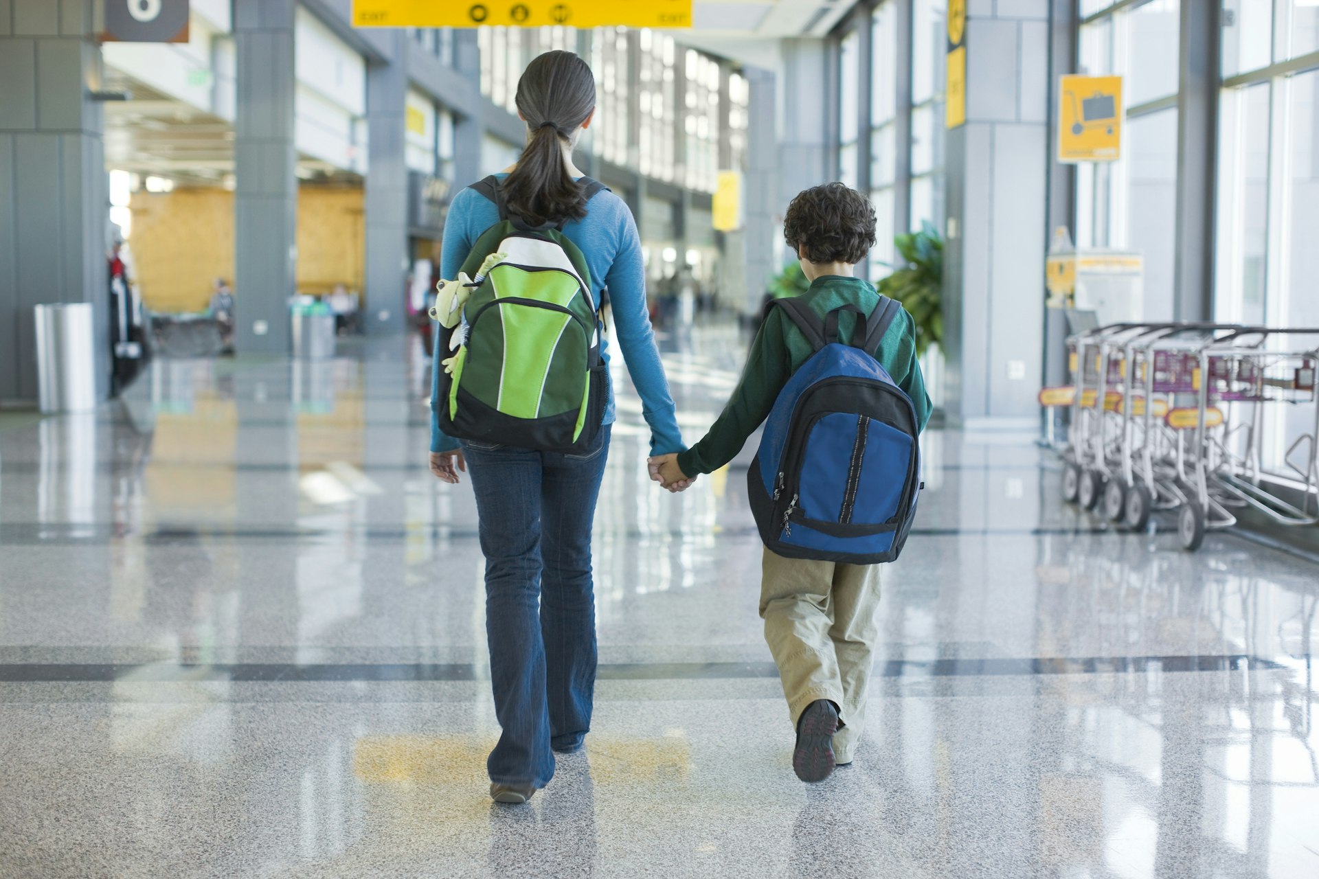 A mother and son walking through the airport terminal in Austin, Texas
