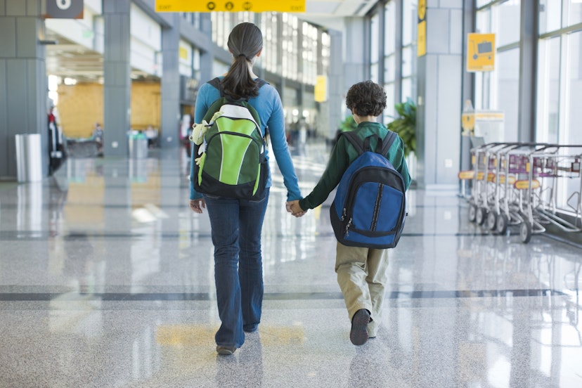 Kids holding hands walking in airport terminal