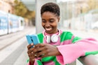 Happy young trendy african woman using mobile phone while waiting for the train at outdoors station
1439709091