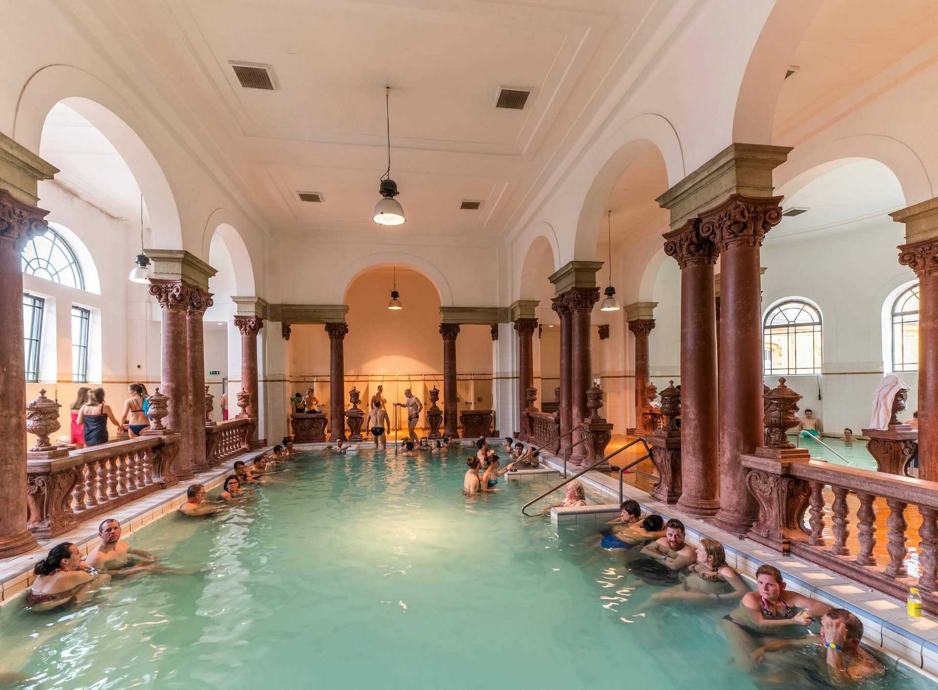 People soak in a large indoor thermal bath