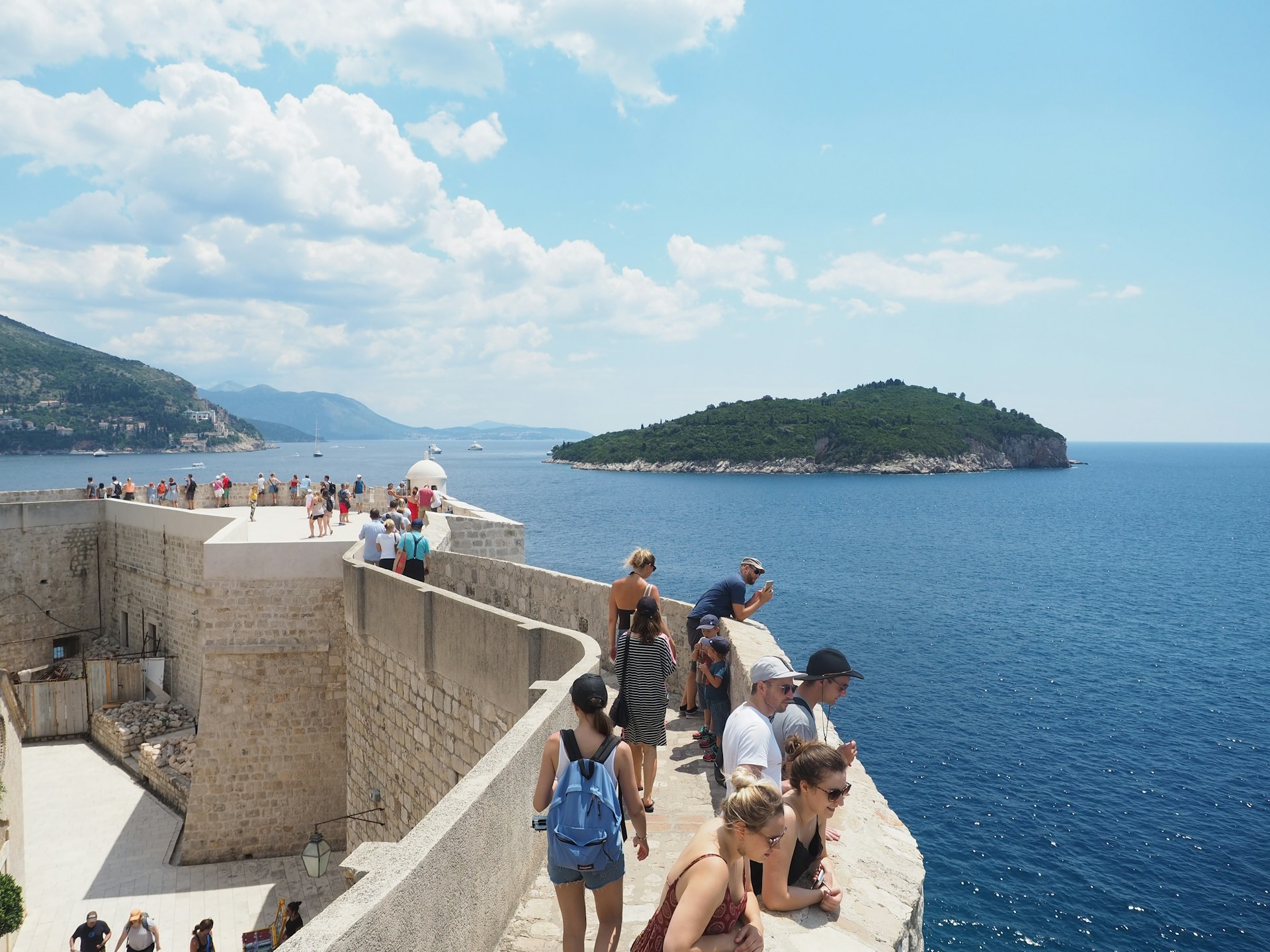 Visitors on the city wall in Dubrovnik's Old Town on a sunny day.