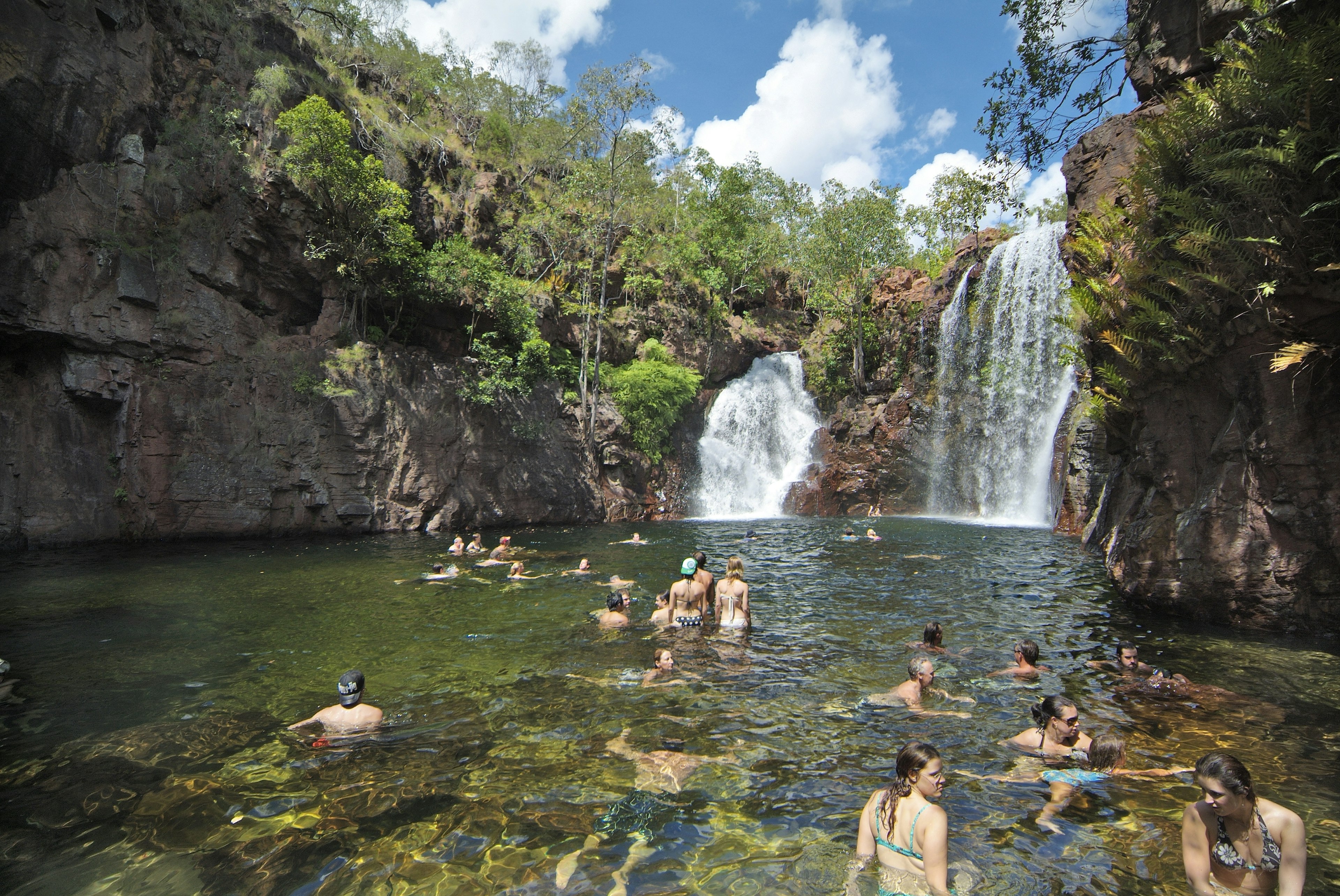 Unidentified people enjoy a swim in the natoral pool of Florence falls in Litchfield National park in Australia Northern Territory,