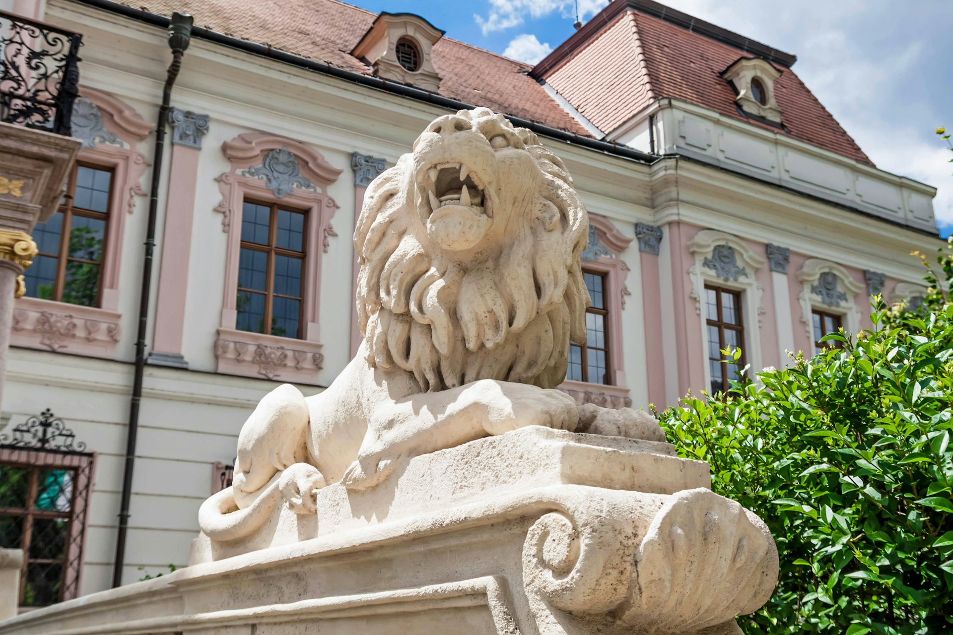 A stone lion outside a grand palace building