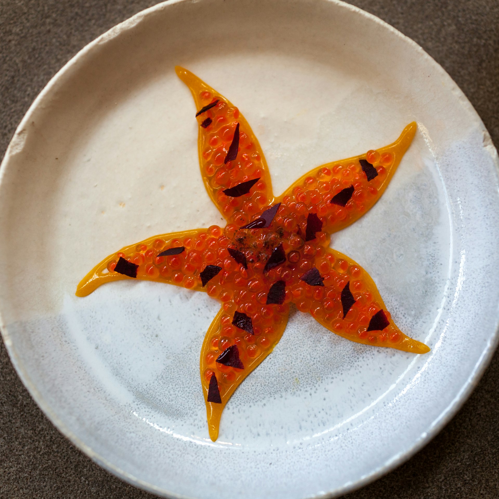 Trout roe with cured egg yolk, shaped like a starfish at noma, Copenhagen, Denmark