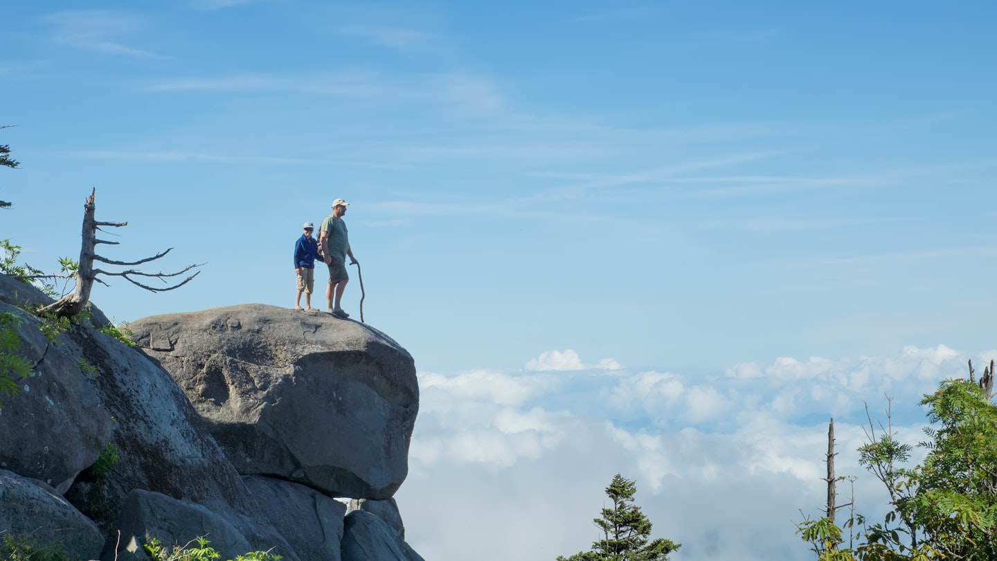 Above the clouds. Father and son on a rock in the National Park Great Smoky Mountains; Shutterstock ID 146553860; your: Claire Naylor; gl: 65050; netsuite: Online Ed; full: Great Smokey Mountains NP things to do
146553860