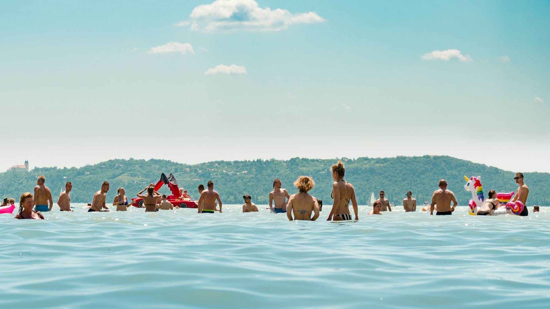 Many swimmers enjoying the waters of a turquoise blue lake