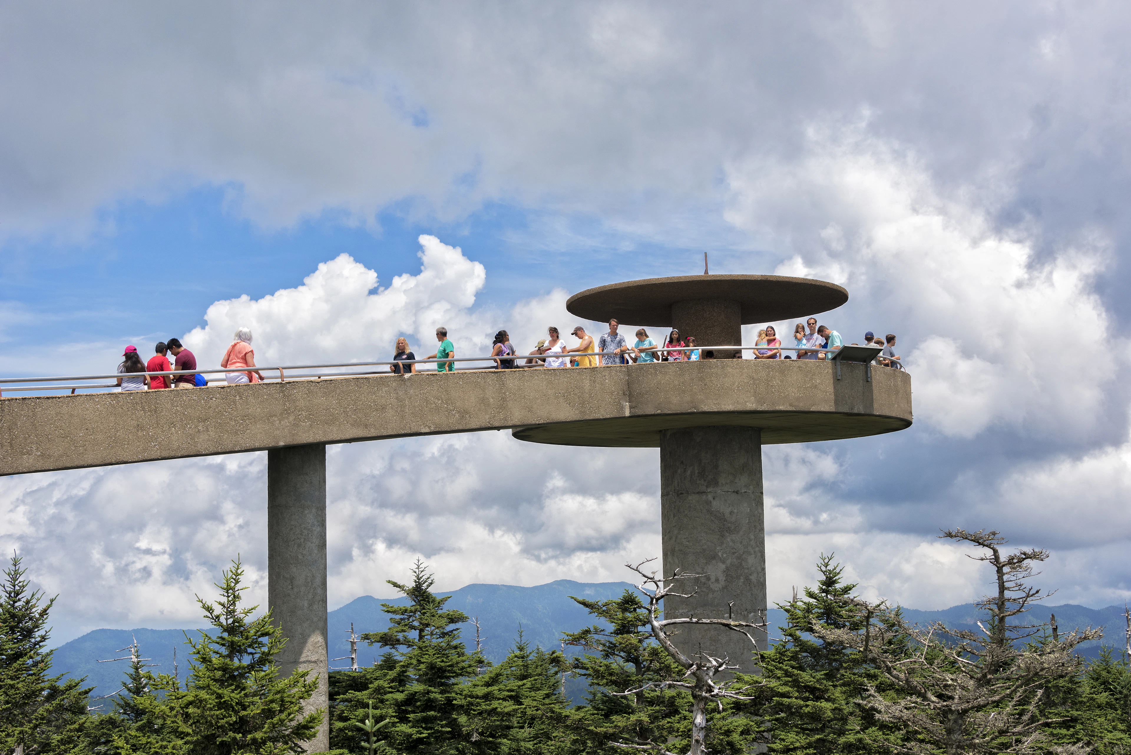 Люди гуляют по бетонной конструкции Clingmans Dome в национальном парке Грейт Смоки Маунтейнс в солнечный день в Теннесси