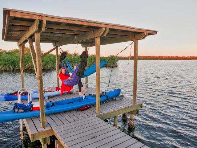 Young girl smiles in camping hammock after kayaking trip in the Florida Everglades.
621974753