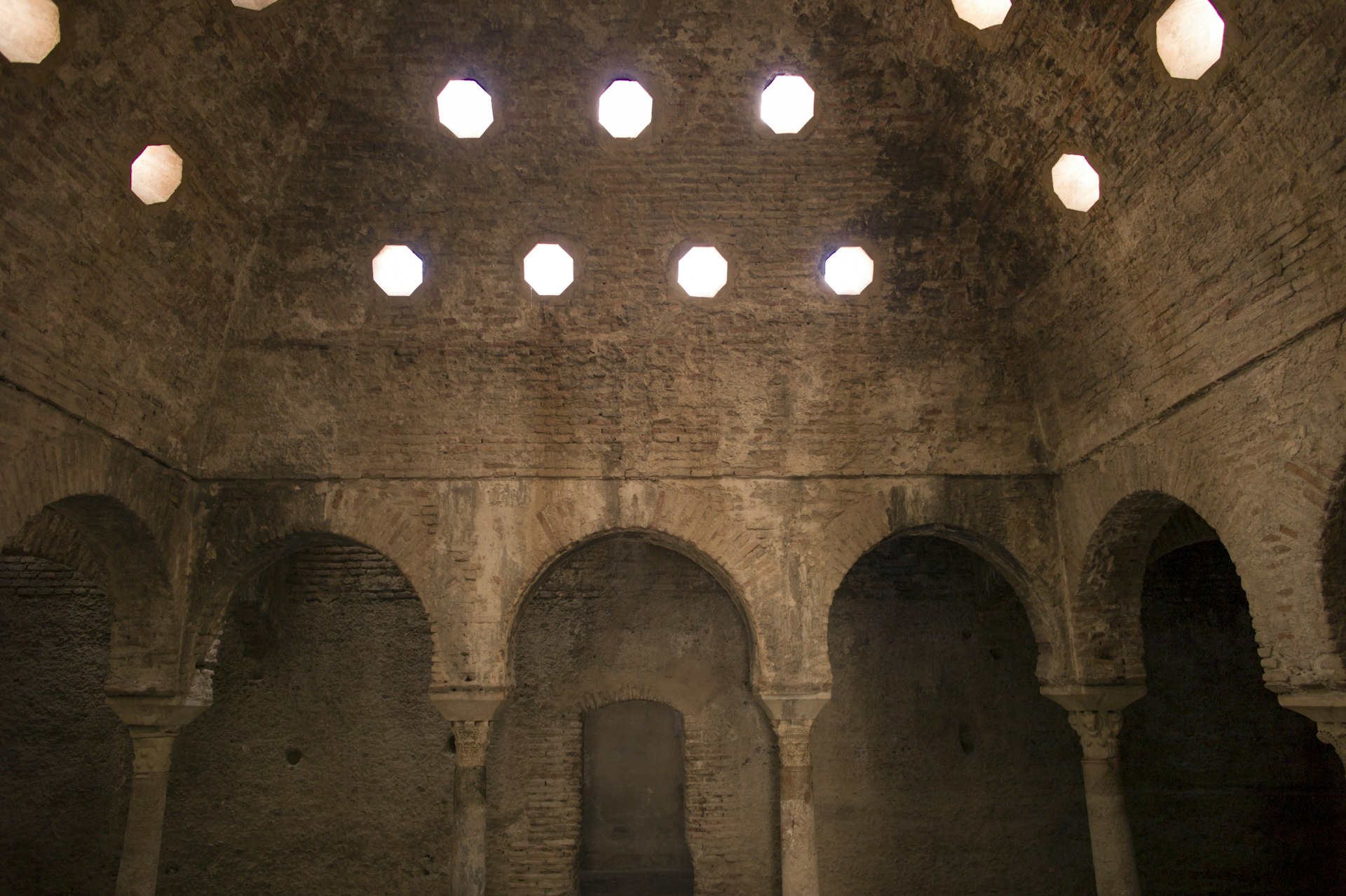 Round windows let in daylight into the historic Hammam Al Ándalus, Granada, Spain