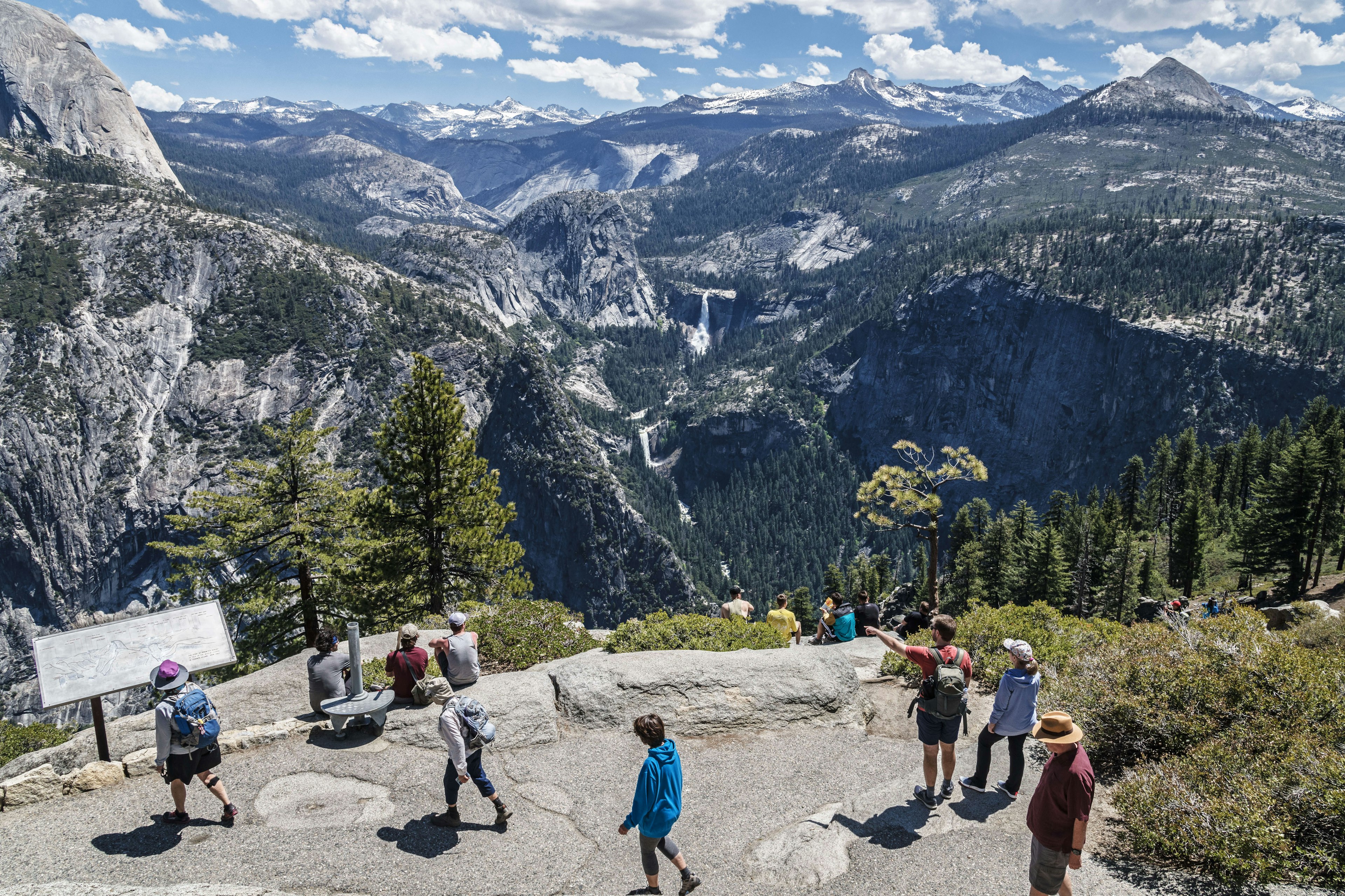 People seen from above, enjoying the view of Nevada and Vernal falls at Glacier Point in Yosemite.