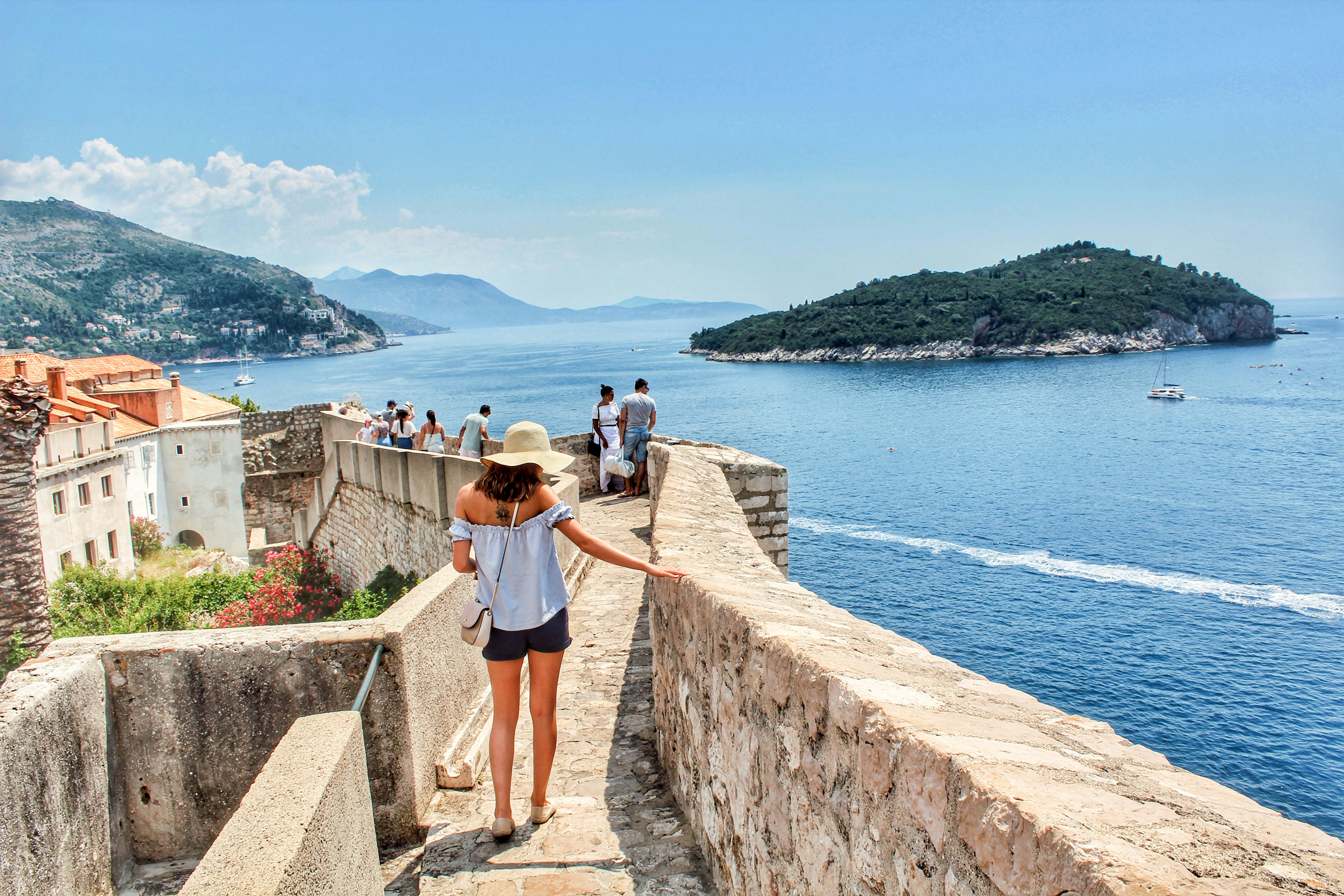 A woman walking the walls of Dubrovnik in Croatia.