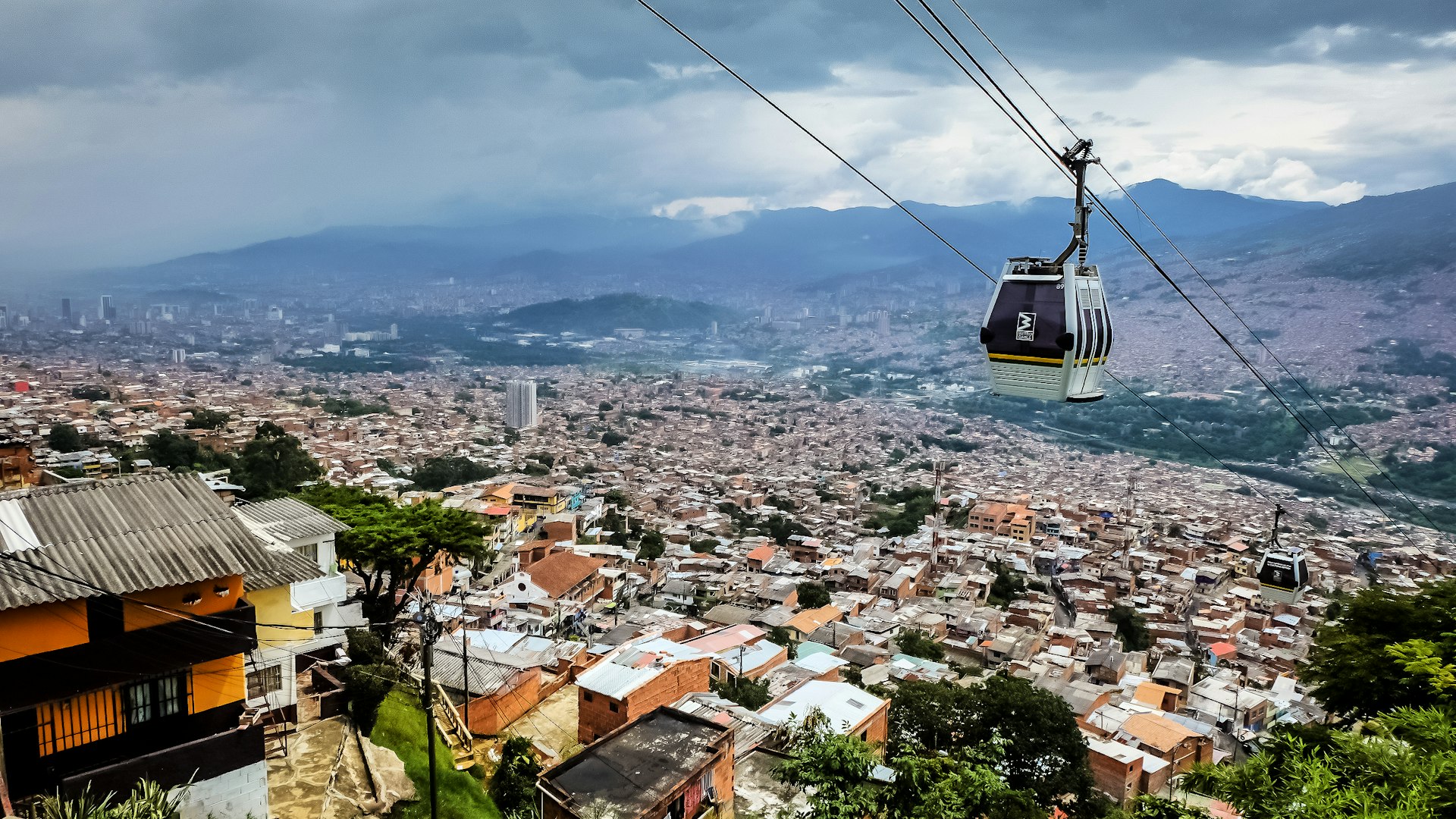 A public-transit gondola passes over hillside neighborhoods of ѱí, Antioquia, Colombia