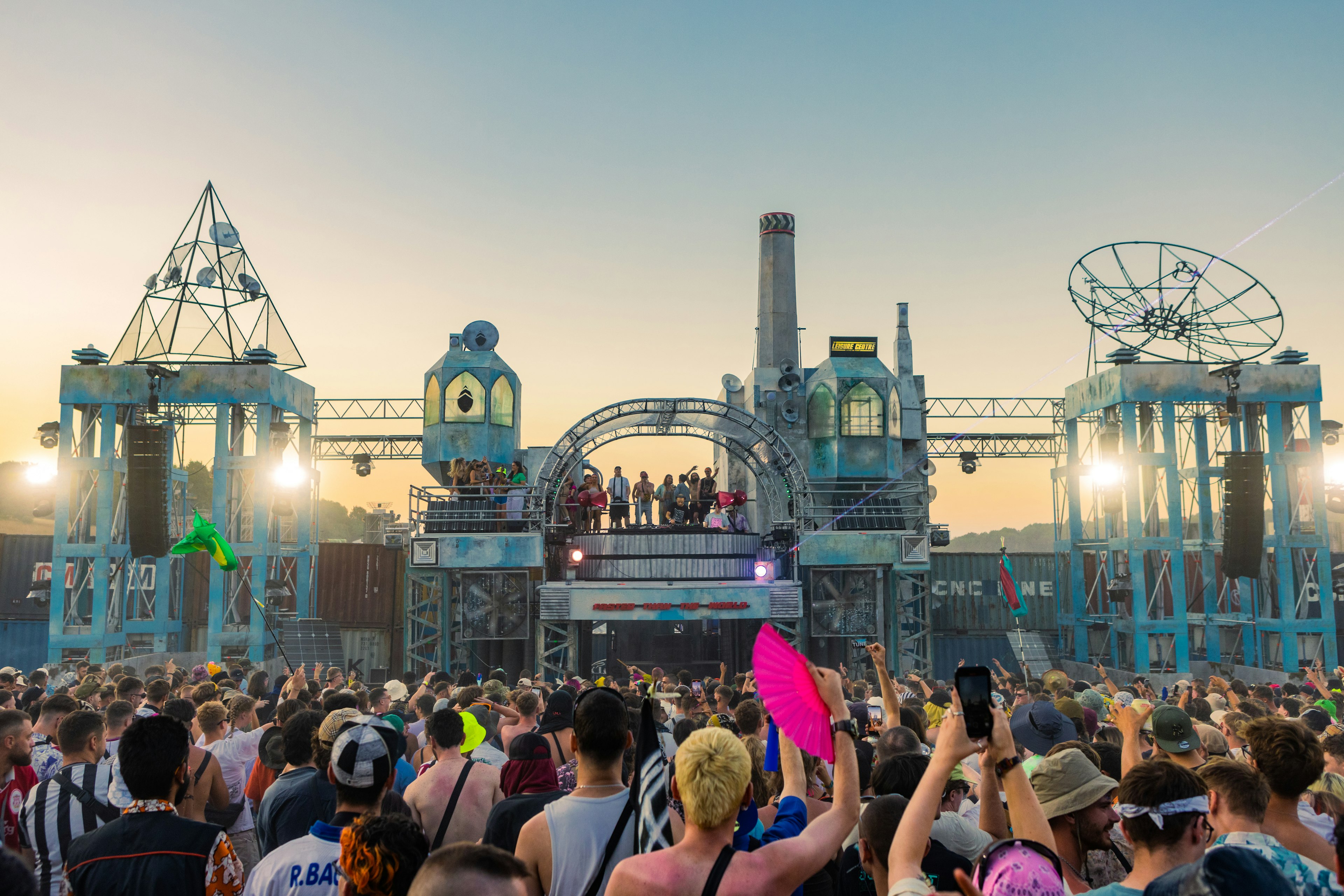 Festival goers enjoying the Boom Town music festival, UK with a stage and colourful crowd