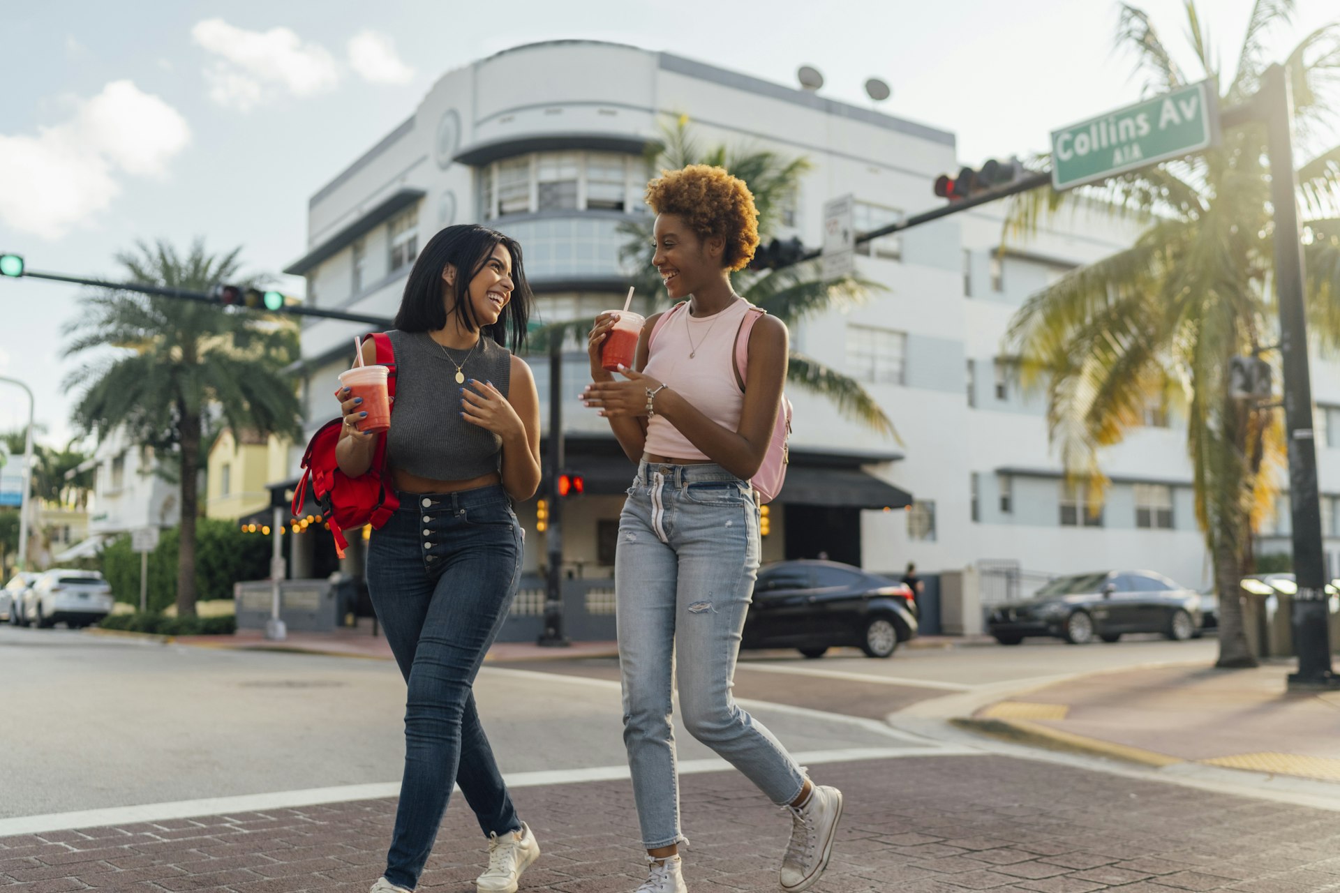 Two women crossing the street in Miami while laughing