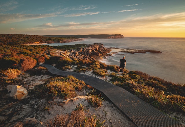 Full Length Of Man Standing On Cliff During Sunset