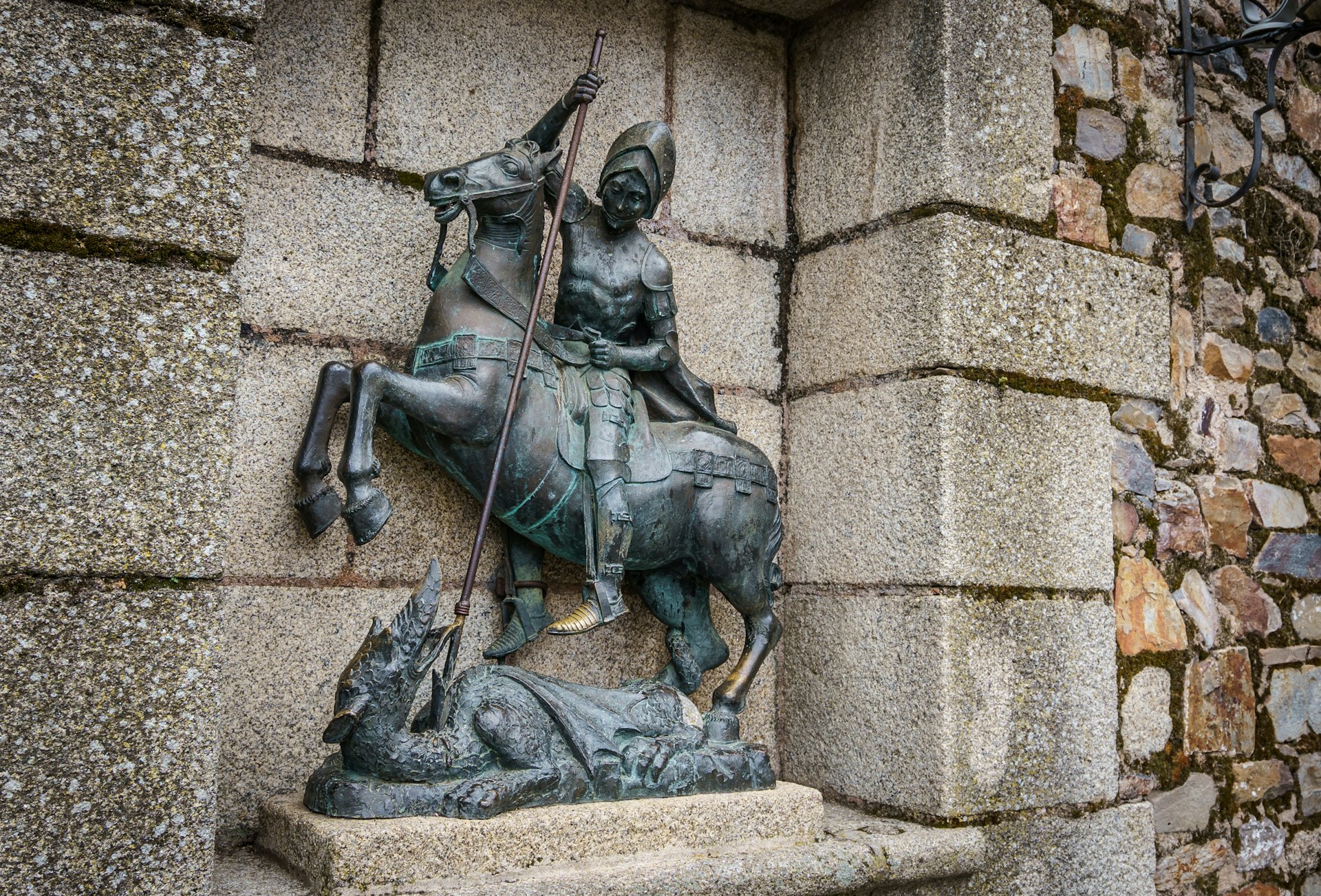 A statue of Saint George conquering a dragon sits in front of a church. 