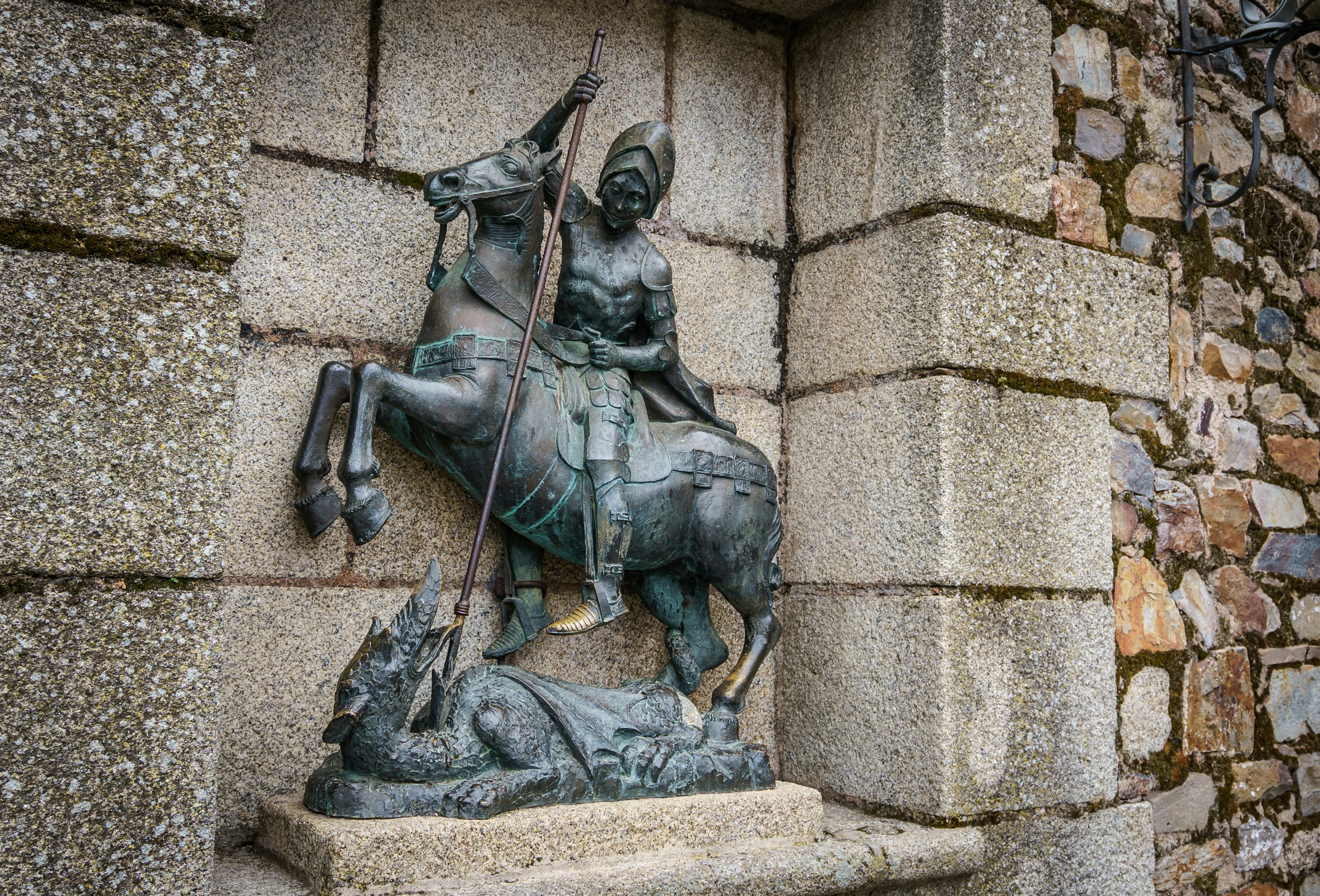 A statue of Saint George conquering a dragon sits in front of a church.