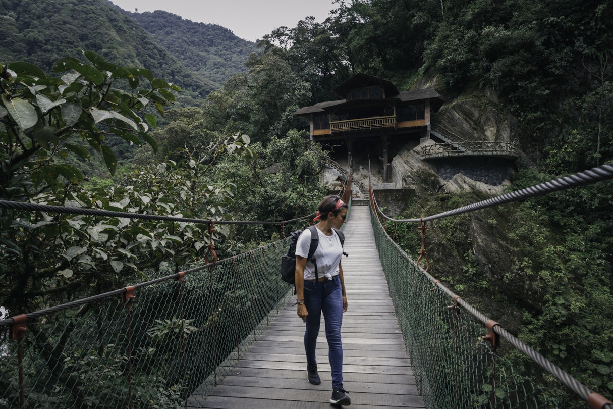 Young woman walking along a suspension bridge towards the camera. Admiring view.
1197828535
Female solo traveler on a suspension bridge surrounded by nature in Ecuador