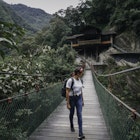 Young woman walking along a suspension bridge towards the camera. Admiring view.
1197828535
Female solo traveler on a suspension bridge surrounded by nature in Ecuador