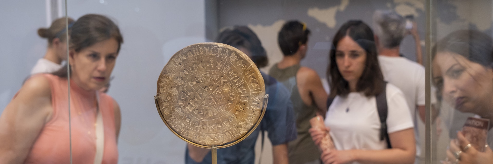 Tourists looking at the Phaistos Disc inside the archaeological museum of Heraklion in Crete that hold the most important and complete collection of the Minoan civilisation of Crete on the 28th of August 2022 in Crete, Greece. Many of the artefacts  in the museum come from Knossos, the largest Bronze Age archaeological site on the Greek island of Crete. (photo by Andrew Aitchison / In pictures via Getty Images)
1245671474
aitchison, greek, heraklion, neolithic, phaistos disc, archaeological, artefacts, ceremonial, civilization, culture, explore, holiday, remains, statues, tourists, viewing