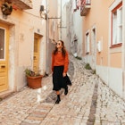 Young woman is walking around Lisbon city center, exploring the neighbourhood on foot
1360370392
A young woman walking along the cobbled streets of Lisbon