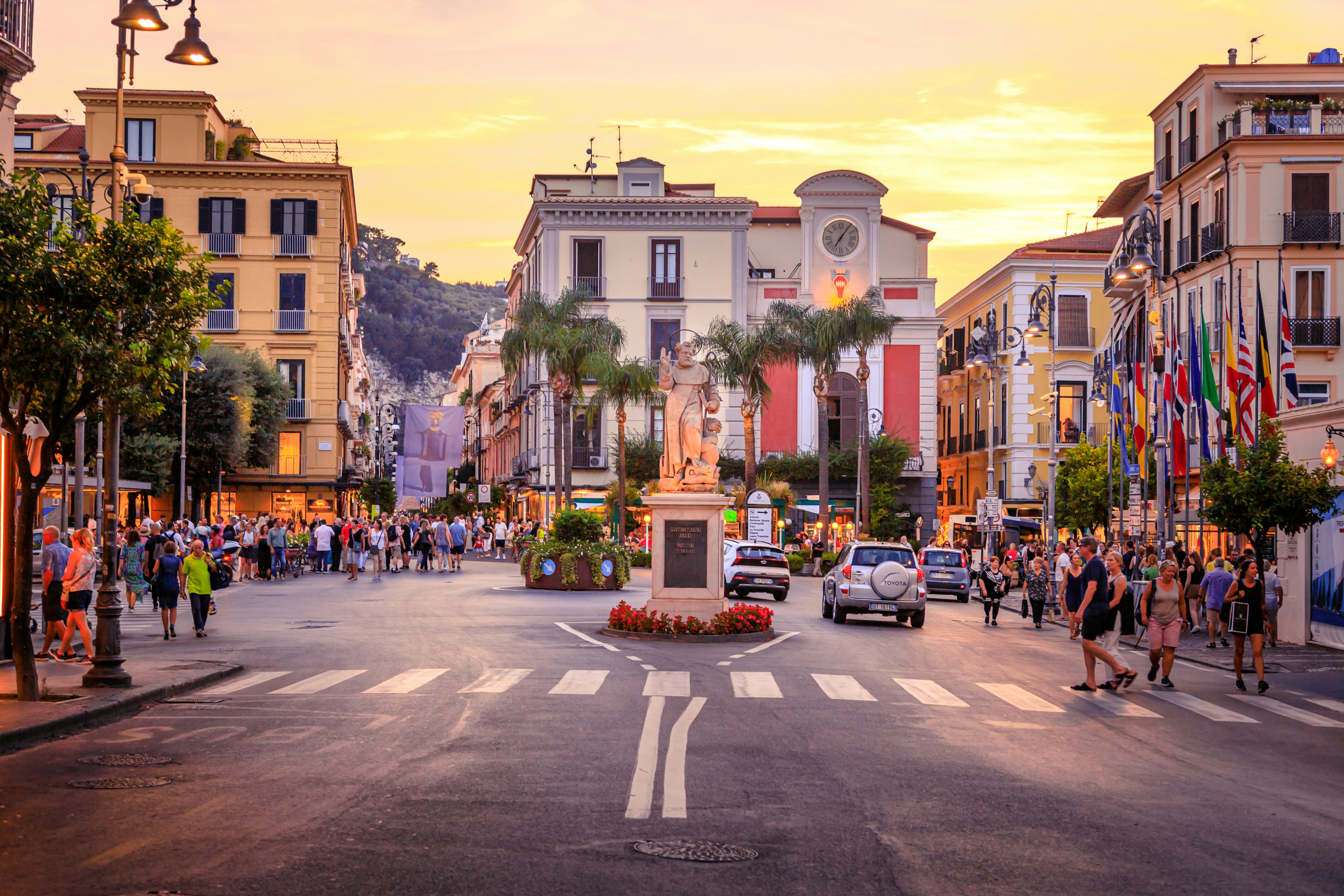 A city square with tourists as the sun sets