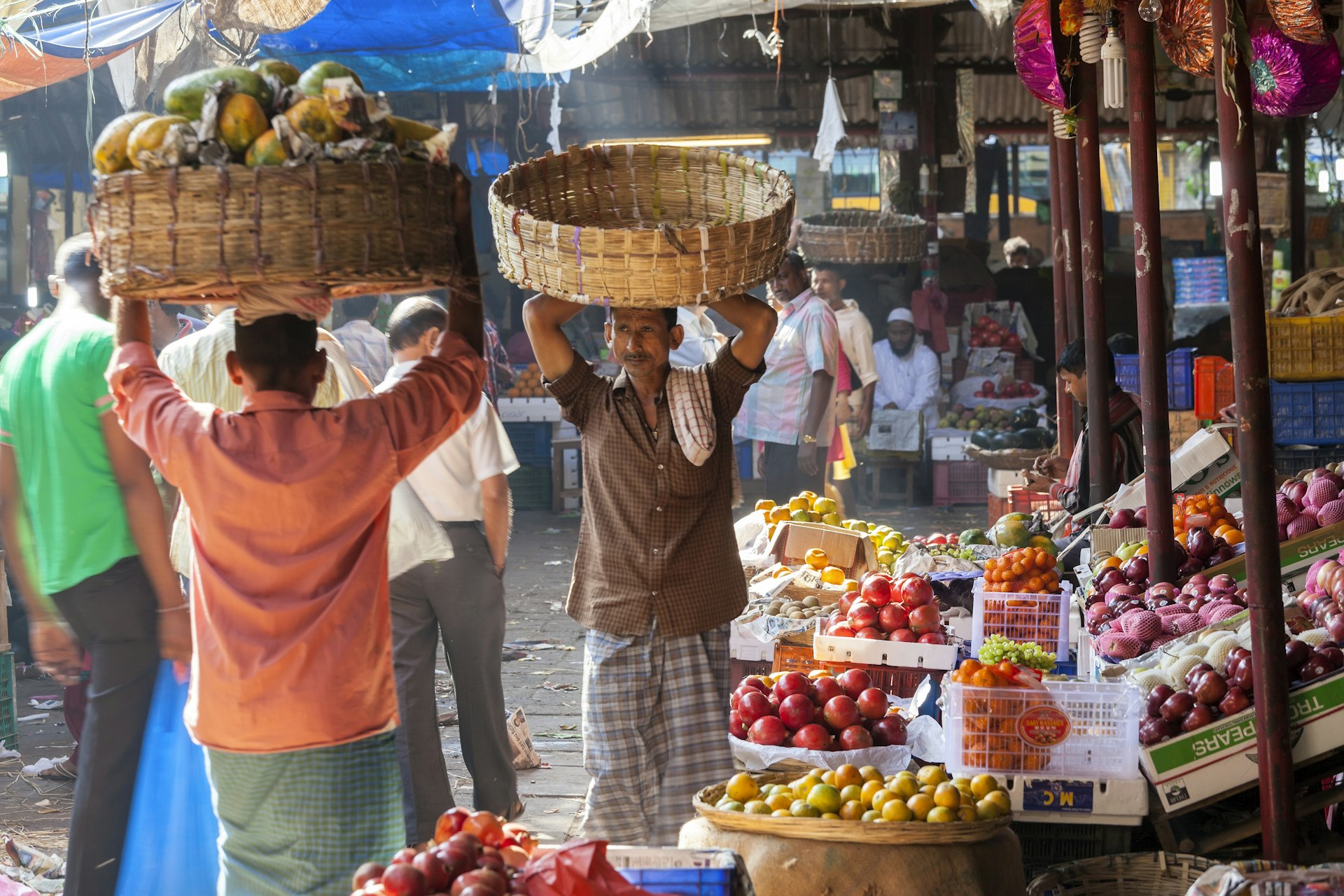 Two men carrying baskets in Crawford Market in Mumbai, India