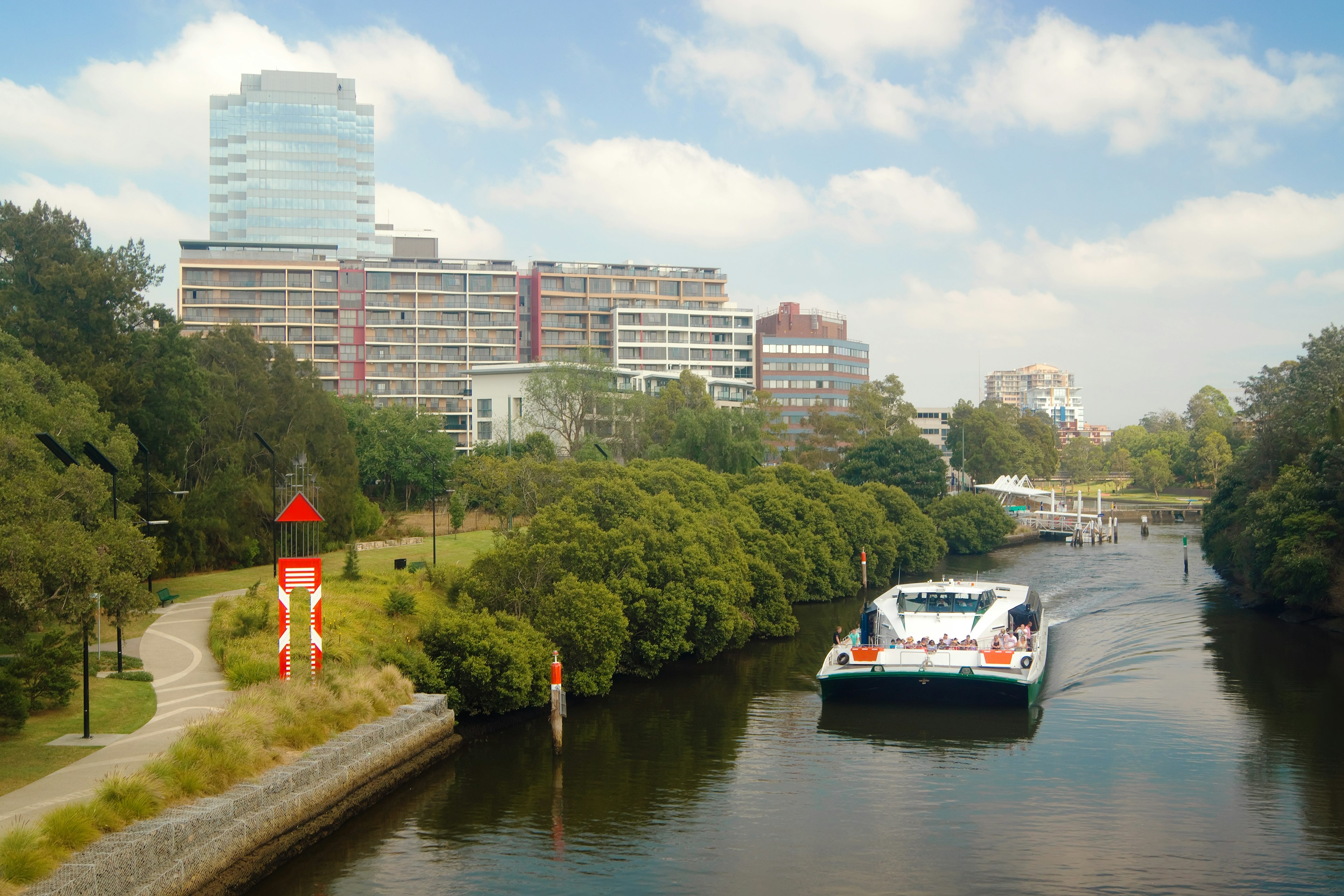 A RiverCat ferry leaves a ferry terminal and cruises along the Parramatta River west of Sydney, New South Wales, Australia