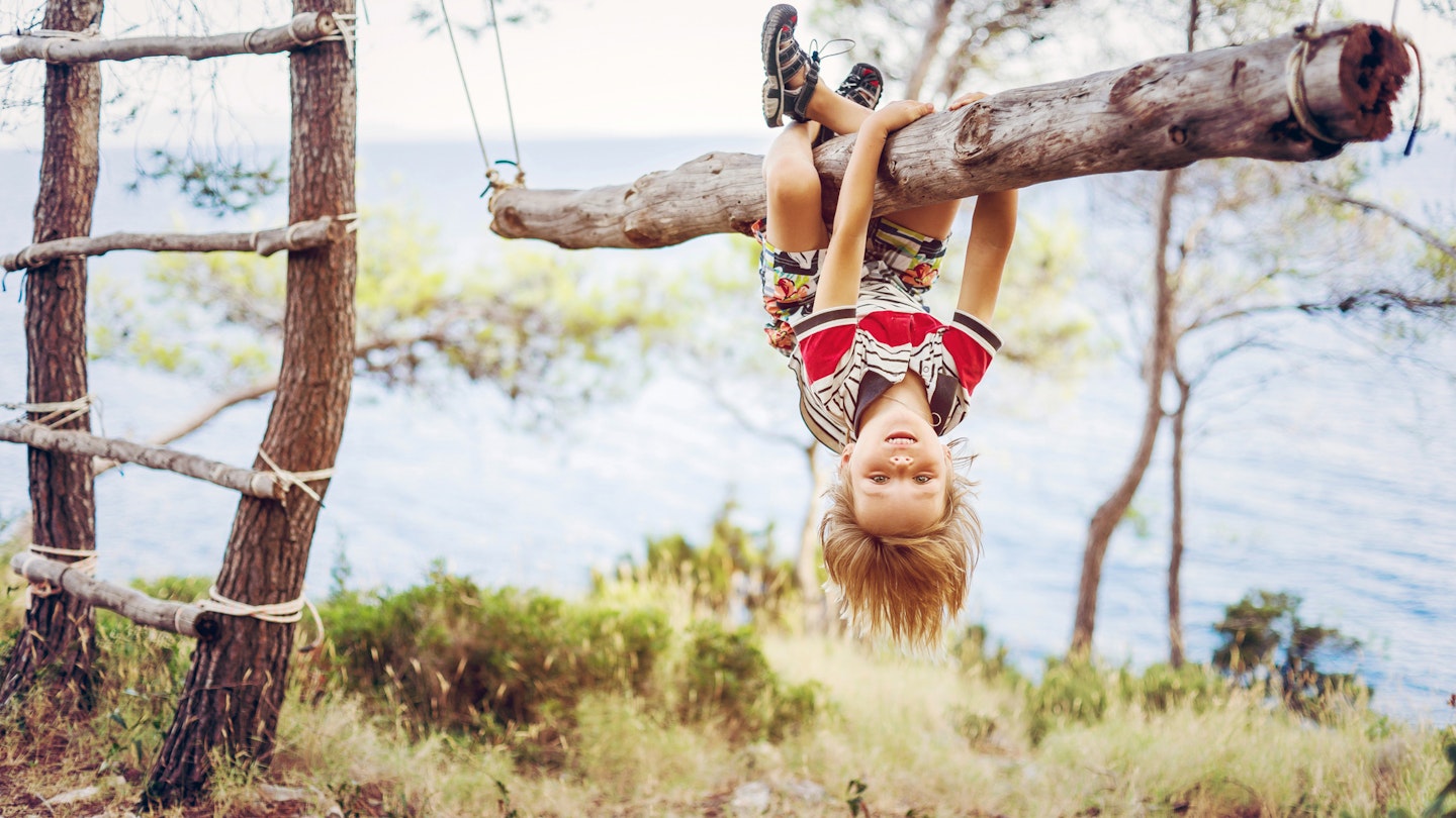 547959655
Exploration, Fun, Enjoyment, Carefree, Confidence
Boy hanging upside down on tree trunk