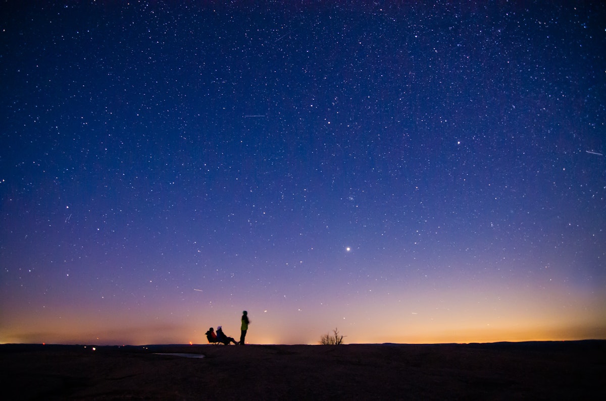 Enchanted Rock State Park is one of the Dark Sky area in available in USA. It is an amazing feelings to lie down on top of the hill and to watch at billions of stars. In this picture 3 person is enjoying the beauty of the universe while one can see the bright Jupiter in distance.